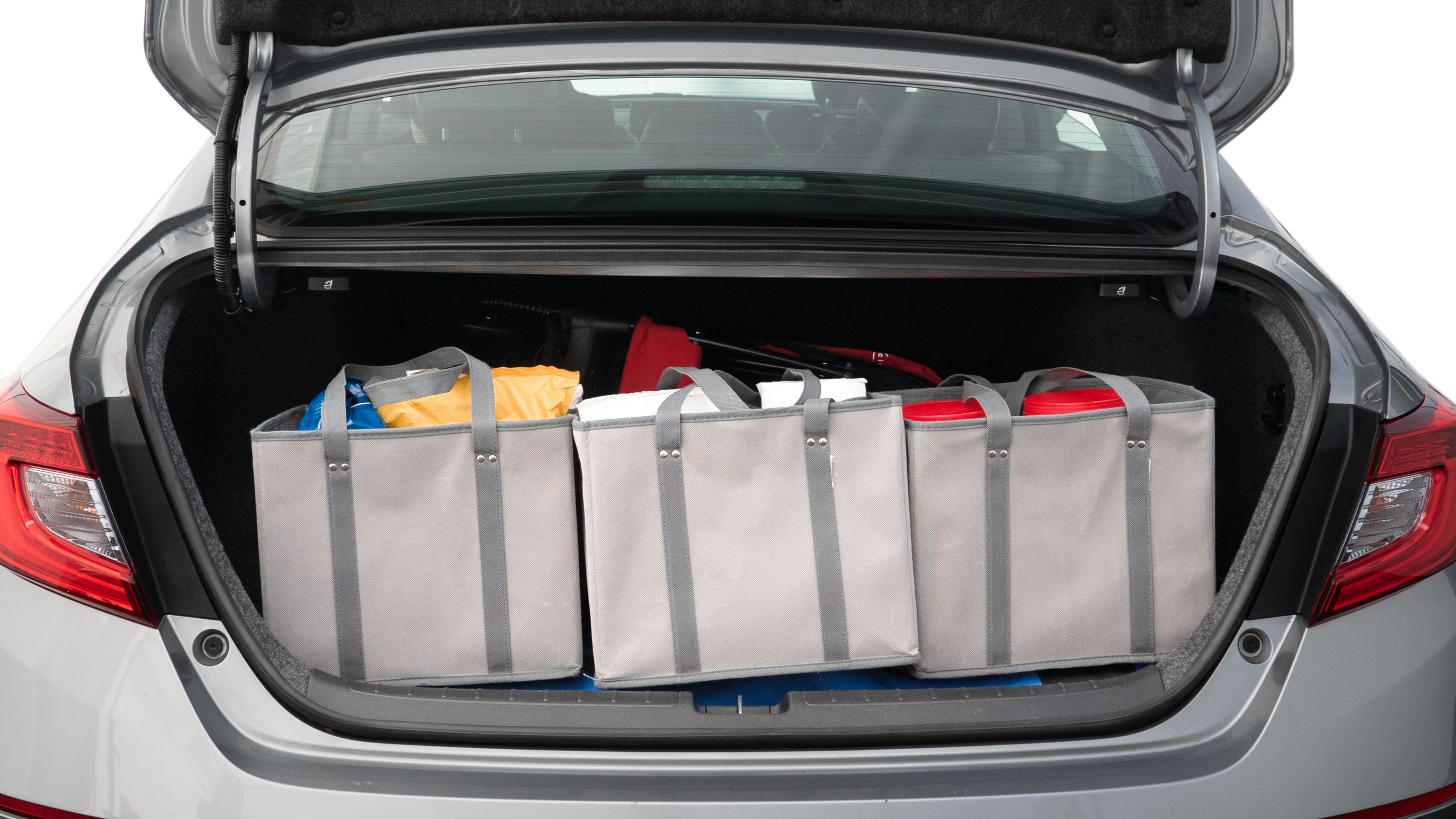 The trunk lid is open showing full view of the trunk. A baby stroller, three grocery carriers, two camping chairs in the carrying bag, and a set of golf clubs are placed inside.