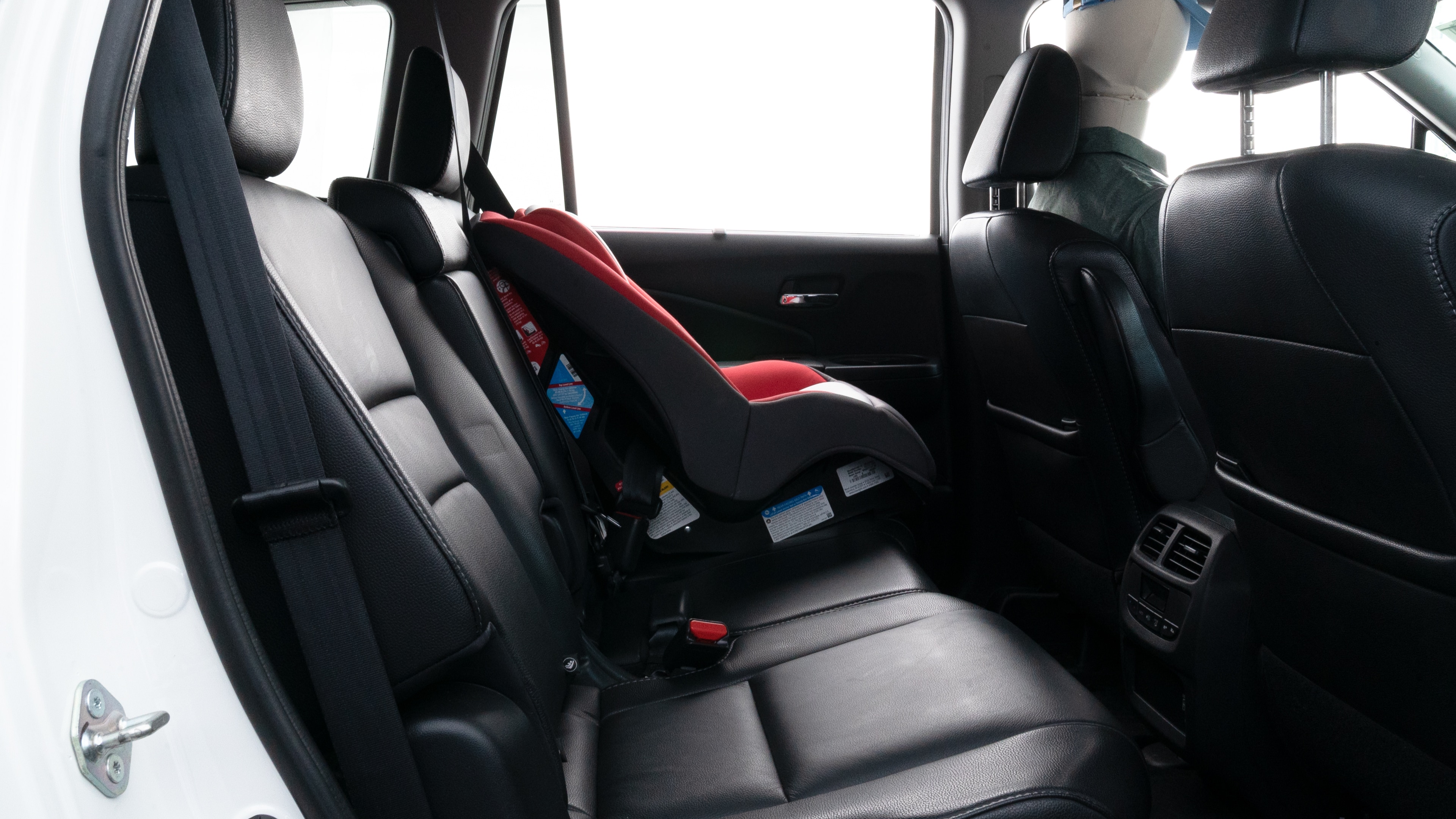A series of second-row backseat photos is shown including one seating a baby seat, a dog and one seating a 6'1" mannequin.