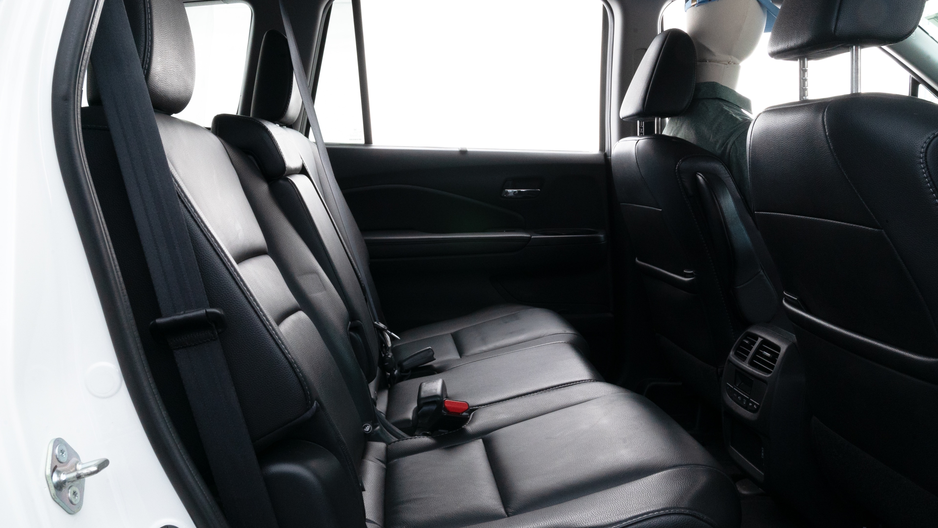 A series of second-row backseat photos is shown including one seating a baby seat, a dog and one seating a 6'1" mannequin.