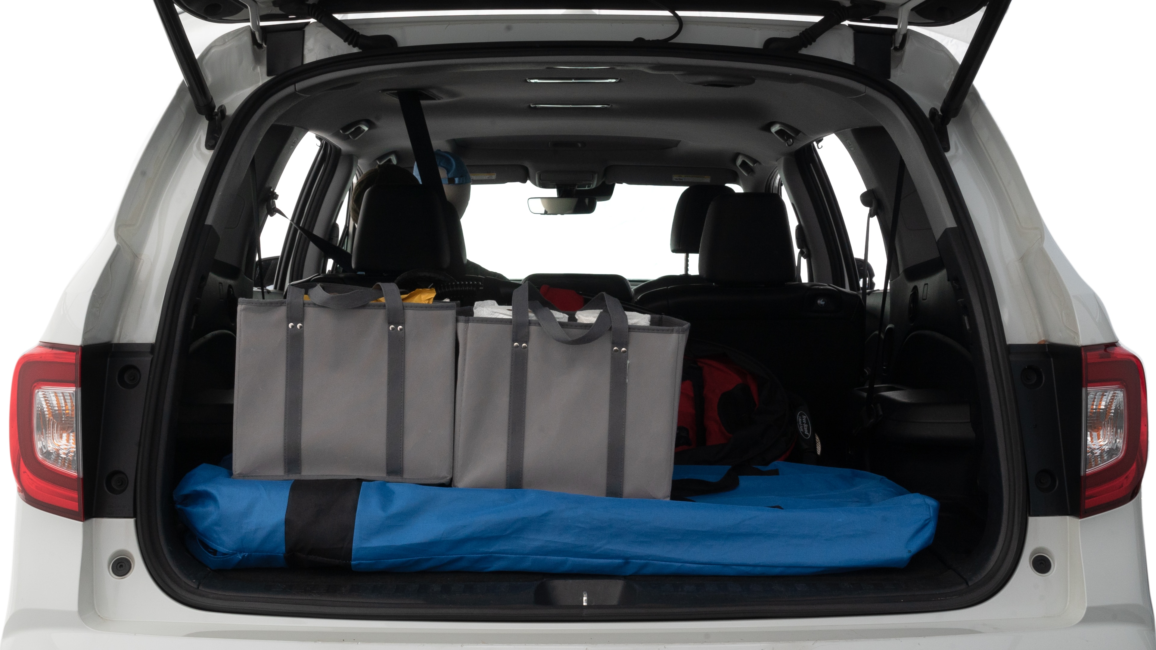The trunk lid is open showing full view of the trunk. A baby stroller, three grocery carriers and two camping chairs in the carrying bag are placed inside.