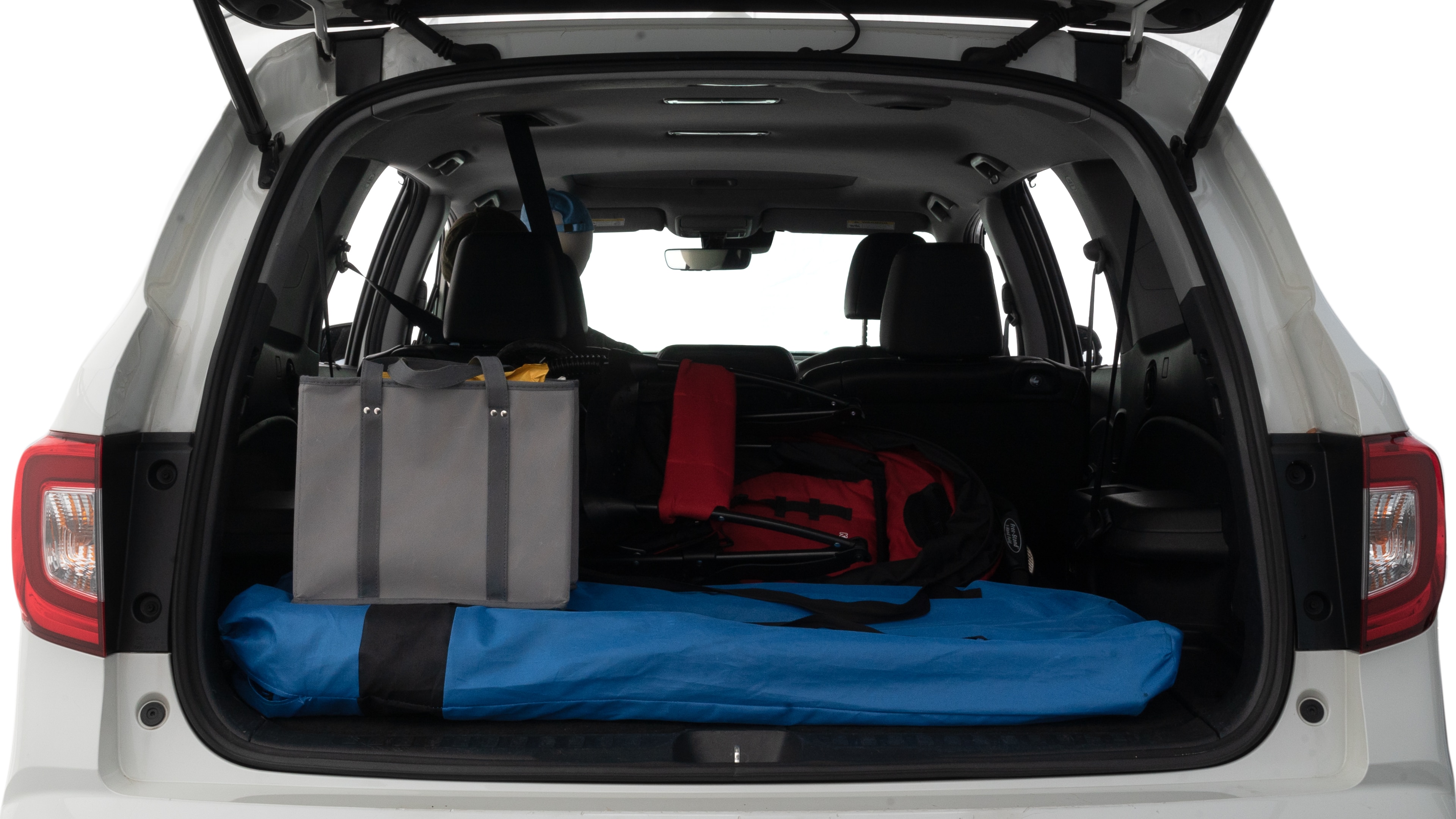 The trunk lid is open showing full view of the trunk. A baby stroller, three grocery carriers and two camping chairs in the carrying bag are placed inside.