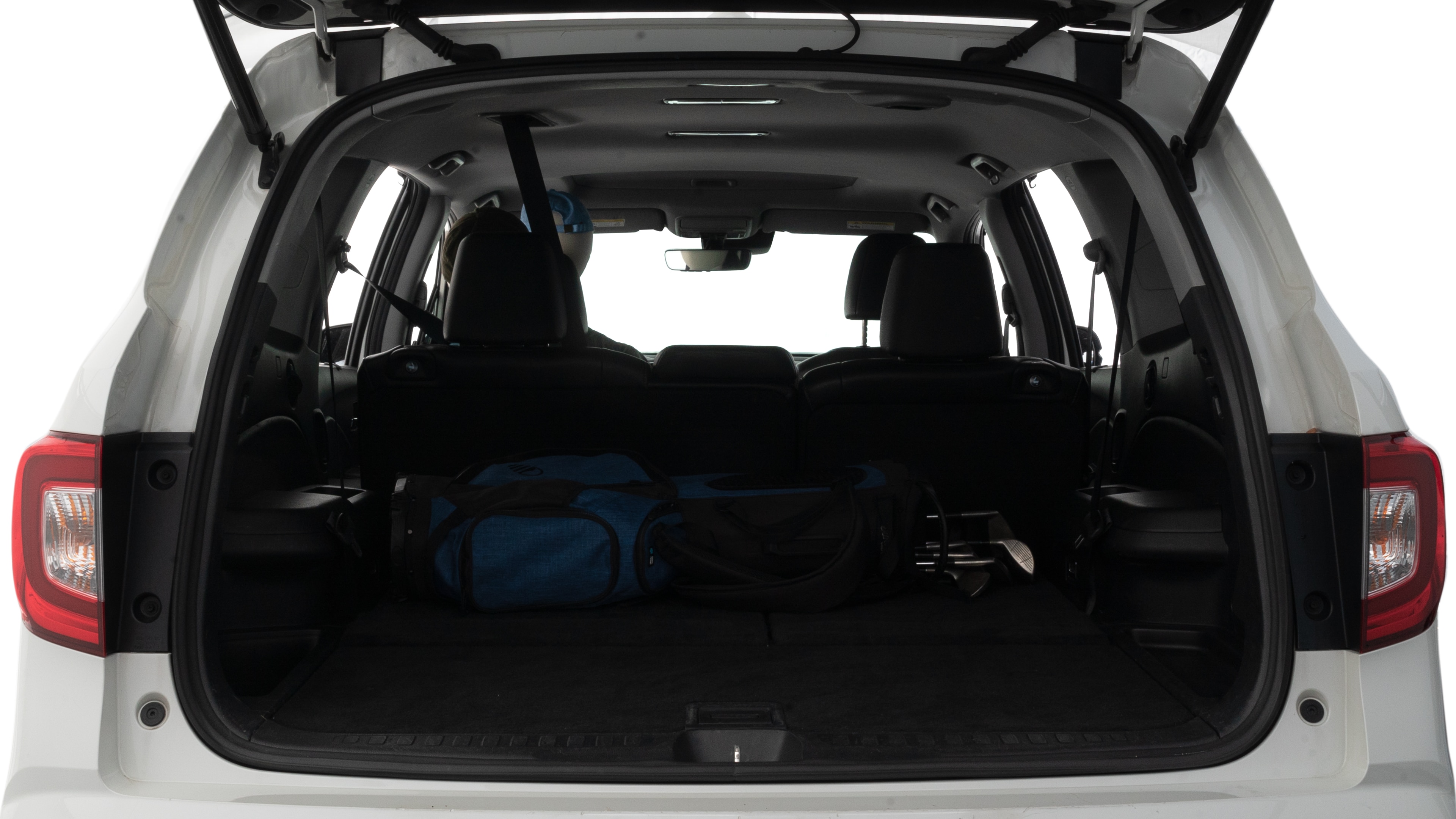 The trunk lid is open showing full view of the trunk. A baby stroller, three grocery carriers and two camping chairs in the carrying bag are placed inside.
