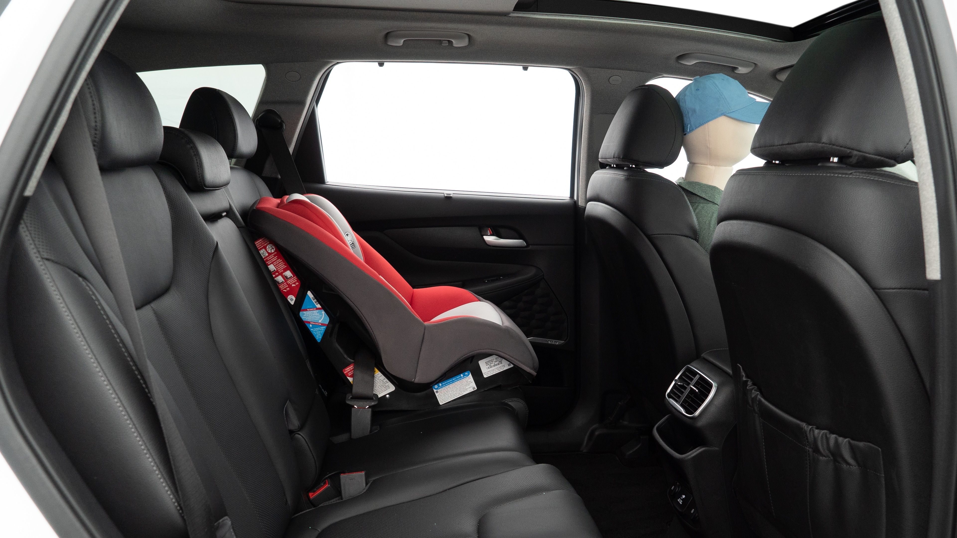 A series of second-row backseat photos is shown including one seating a baby seat and one seating a 6'1" mannequin.