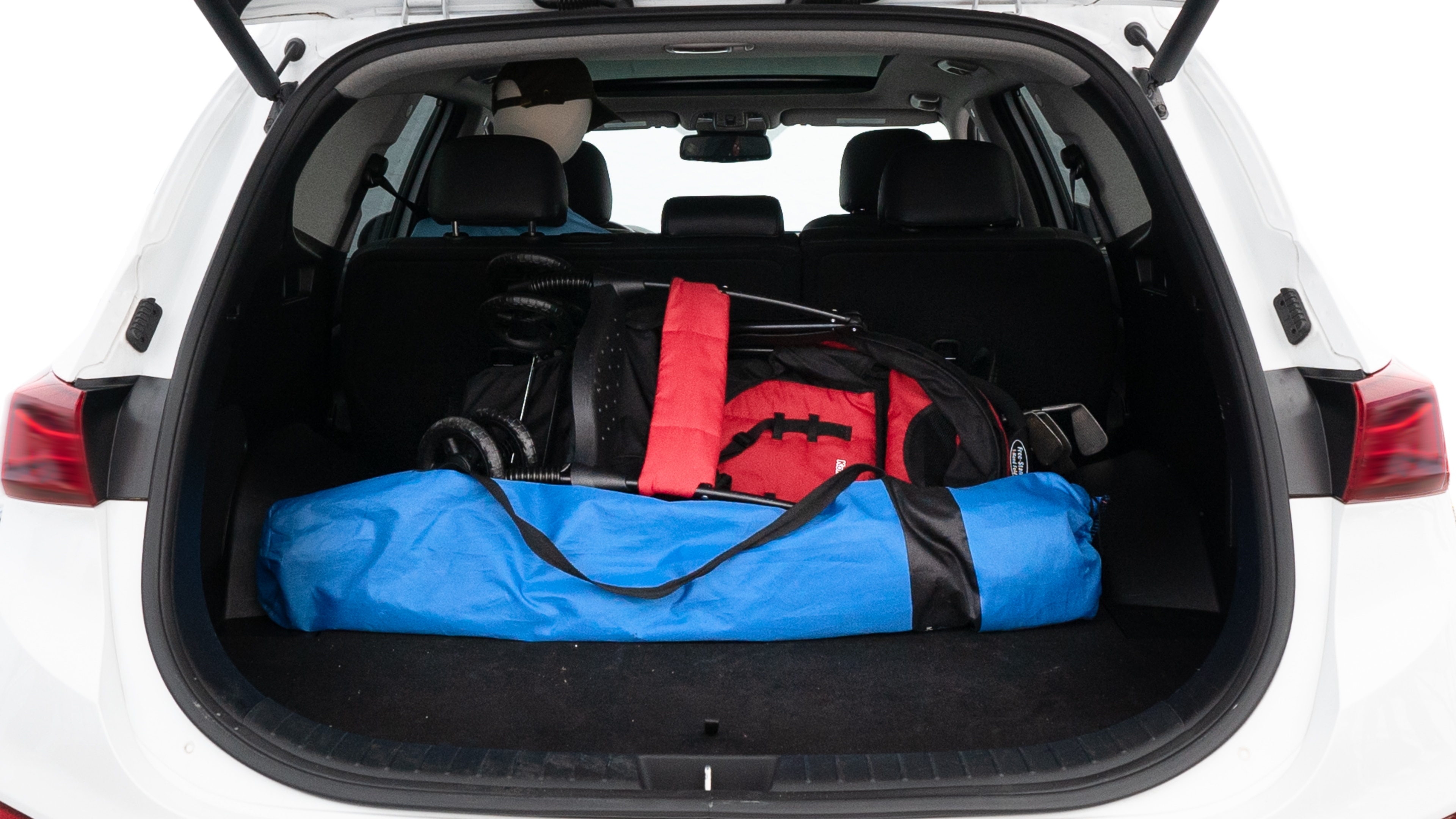 The trunk lid is open showing full view of the trunk. A baby stroller, three grocery carriers, two camping chairs in the carrying bag, and a set of golf clubs are placed inside.