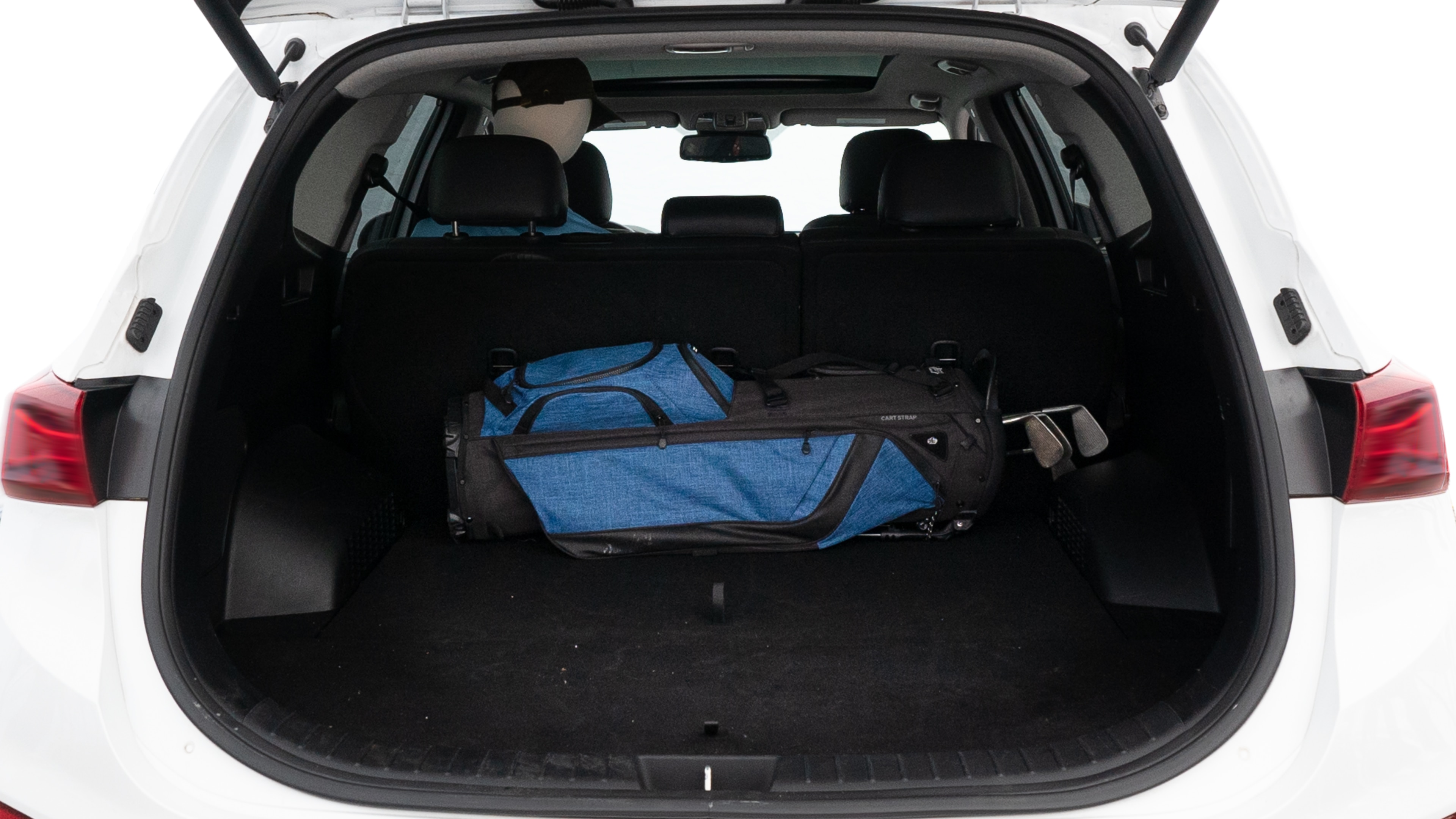 The trunk lid is open showing full view of the trunk. A baby stroller, three grocery carriers, two camping chairs in the carrying bag, and a set of golf clubs are placed inside.