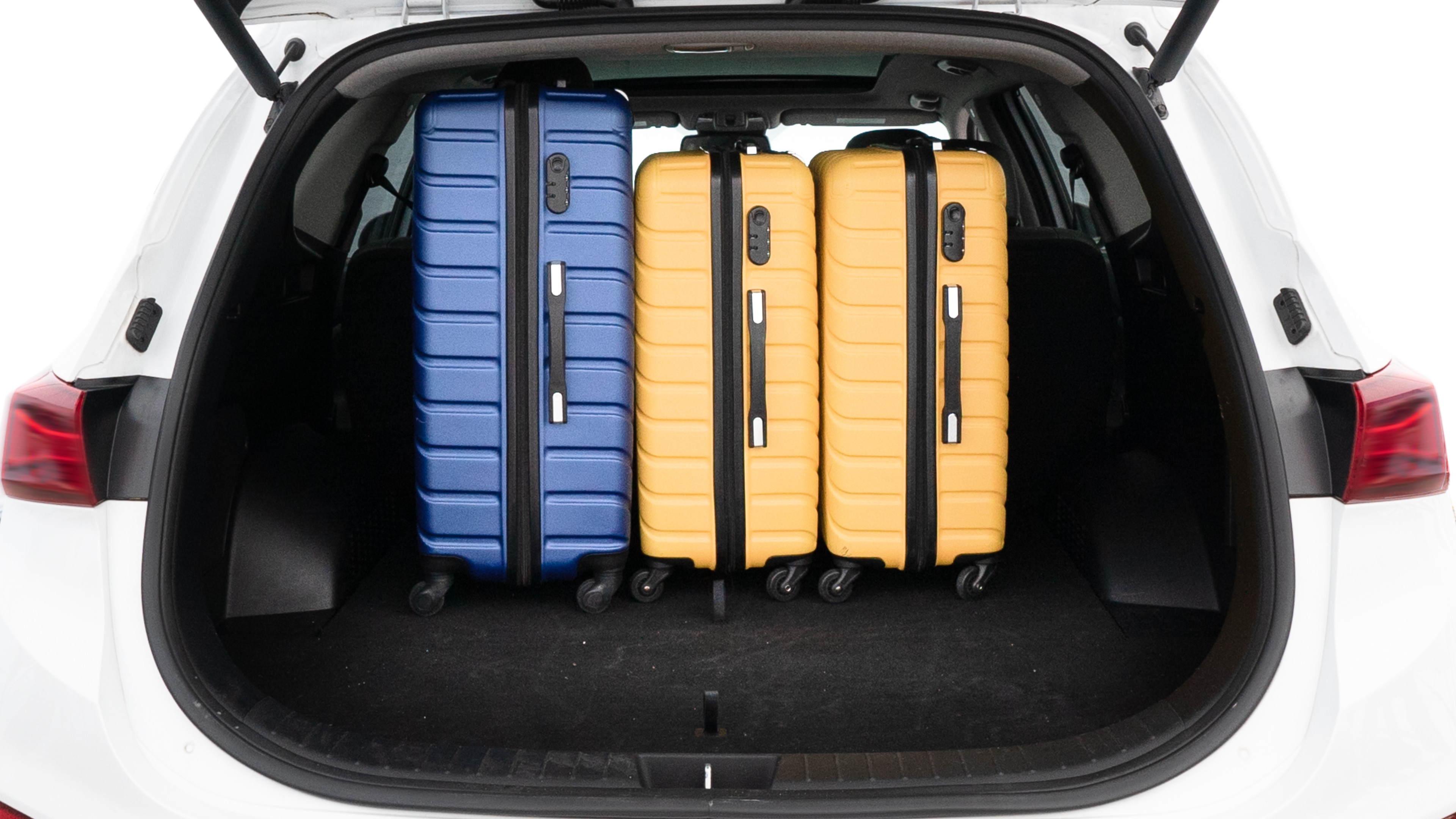 The trunk lid is open, showing full view of the trunk space. One large, two medium, and two small suitcases are placed inside.