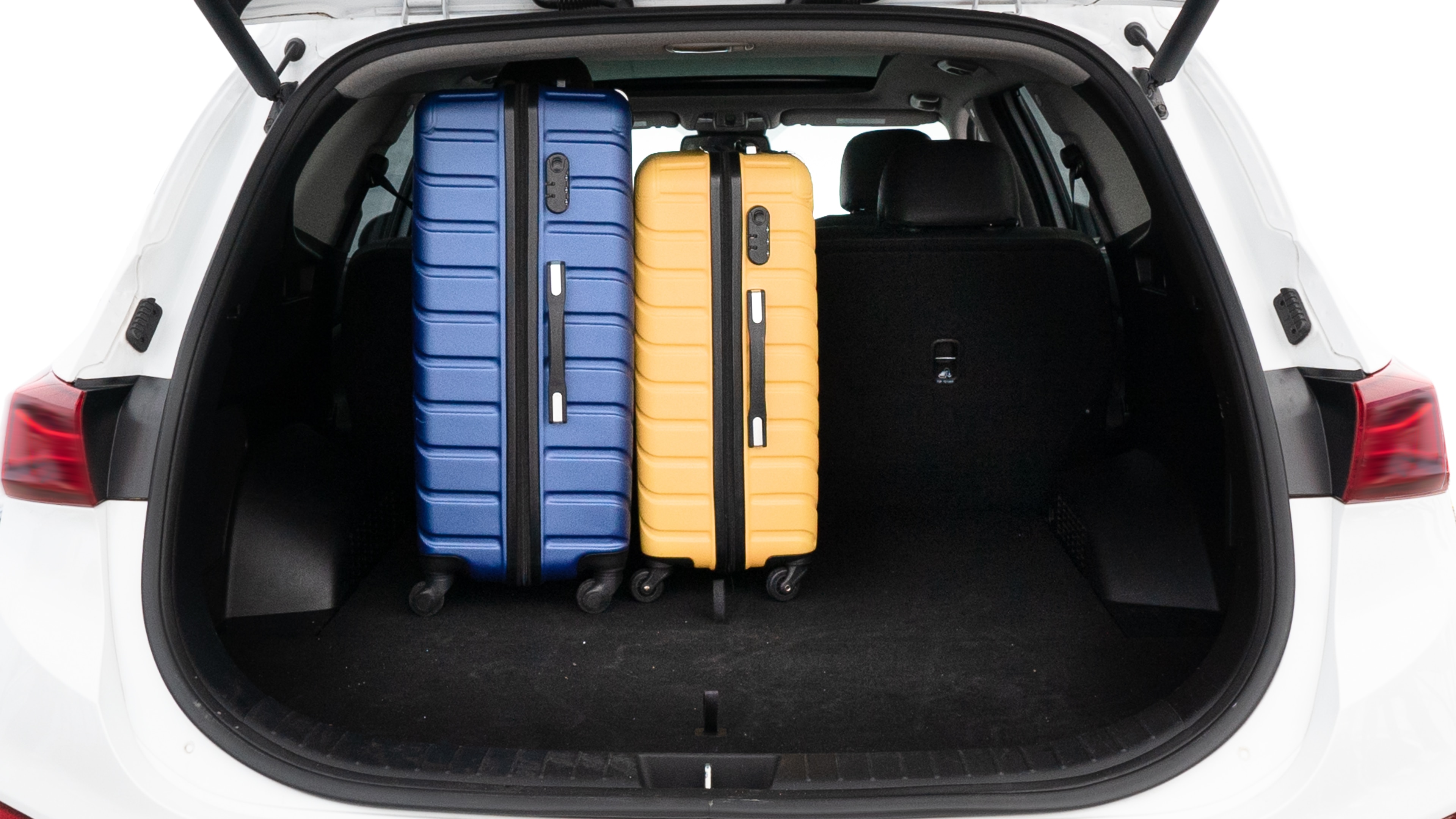 The trunk lid is open, showing full view of the trunk space. One large, two medium, and two small suitcases are placed inside.