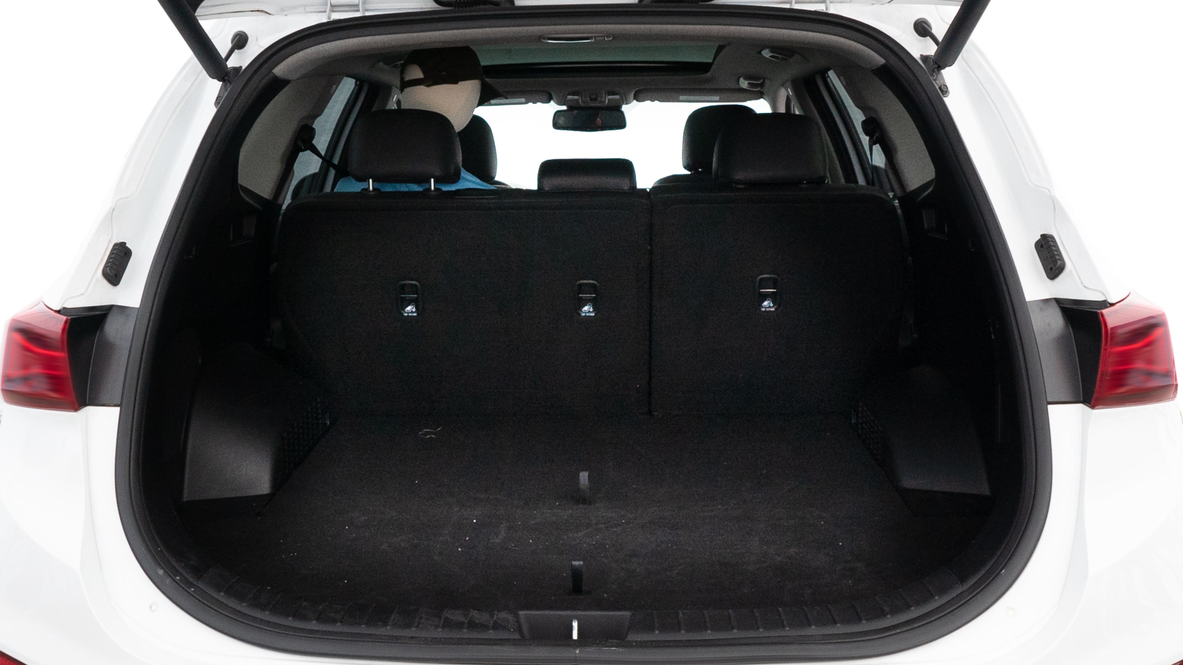 The trunk lid is open, showing full view of the trunk space. One large, two medium, and two small suitcases are placed inside.