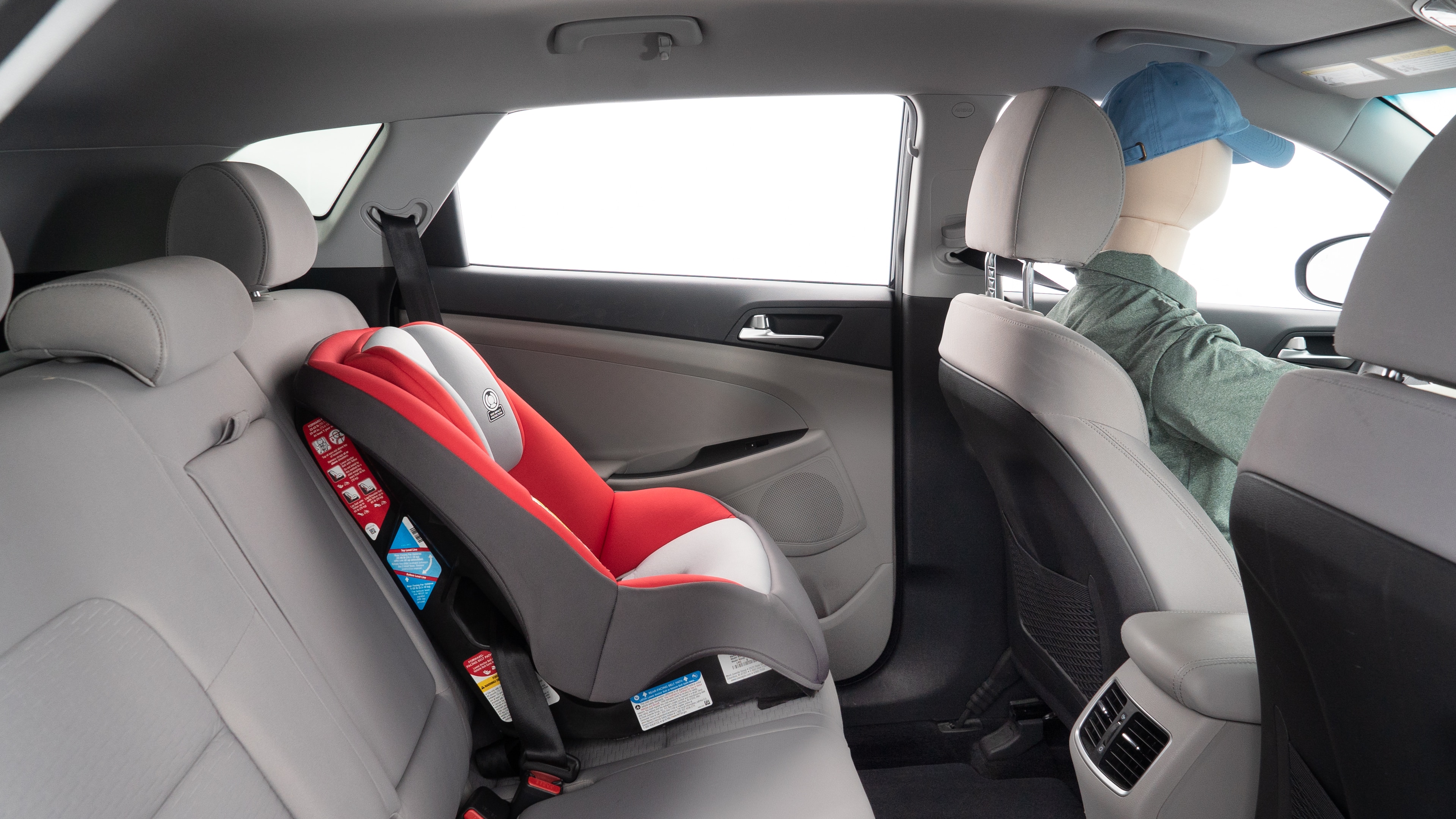 A series of second-row backseat photos is shown including one seating a baby seat and one seating a 6'1" mannequin.