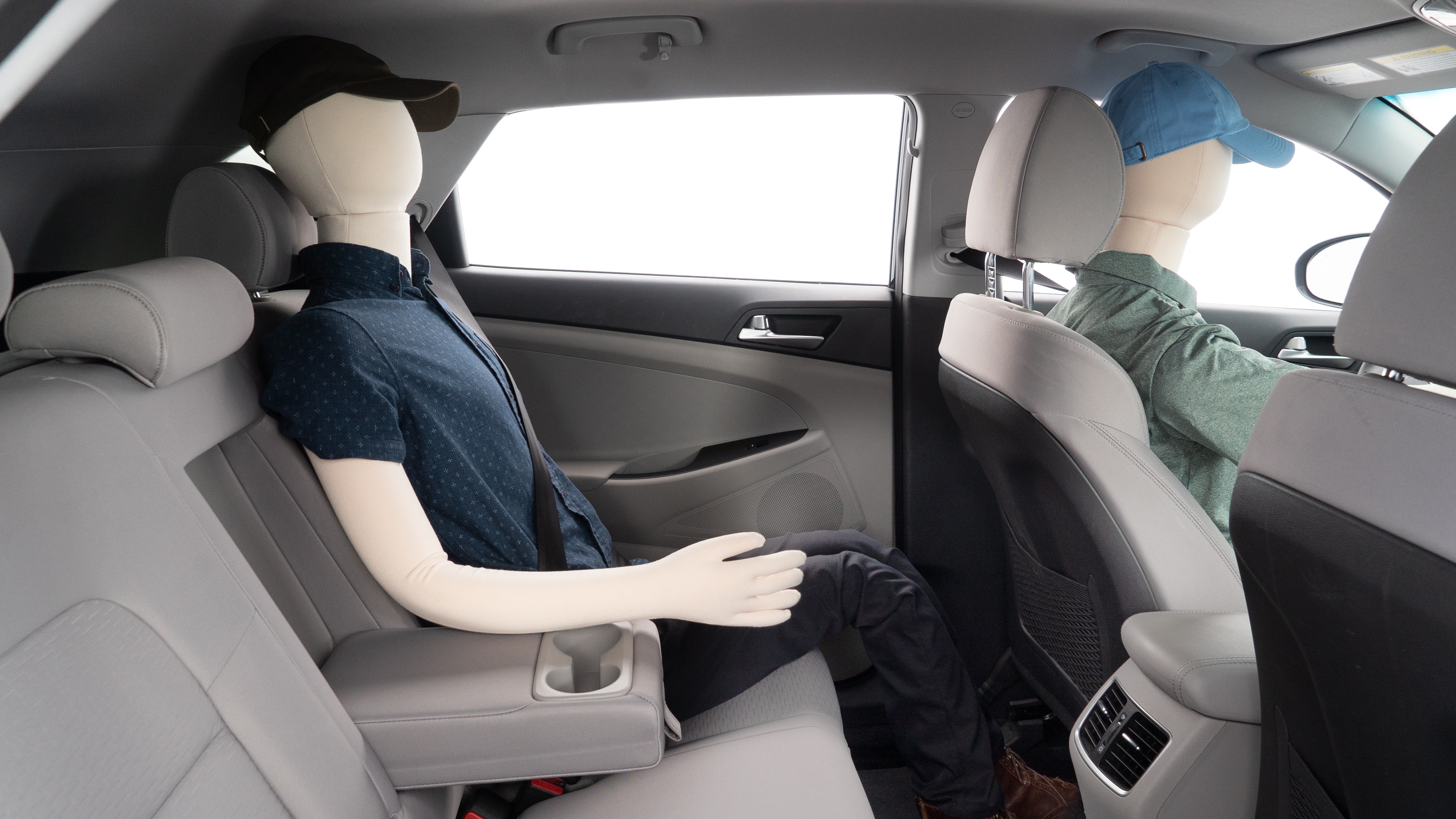A series of second-row backseat photos is shown including one seating a baby seat and one seating a 6'1" mannequin.
