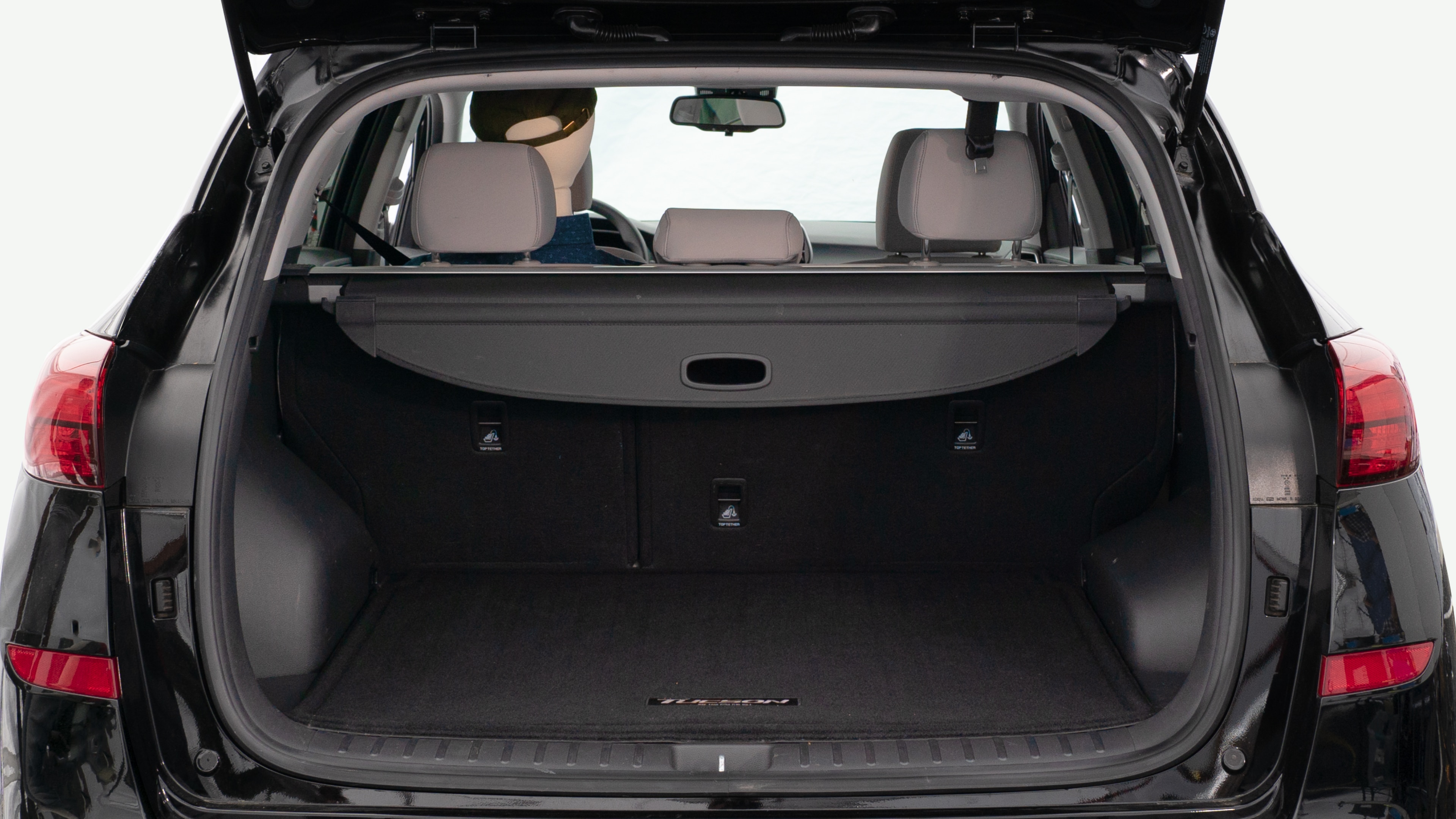 The trunk lid is open showing full view of the trunk. A baby stroller, three grocery carriers, and a set of golf clubs are placed inside.