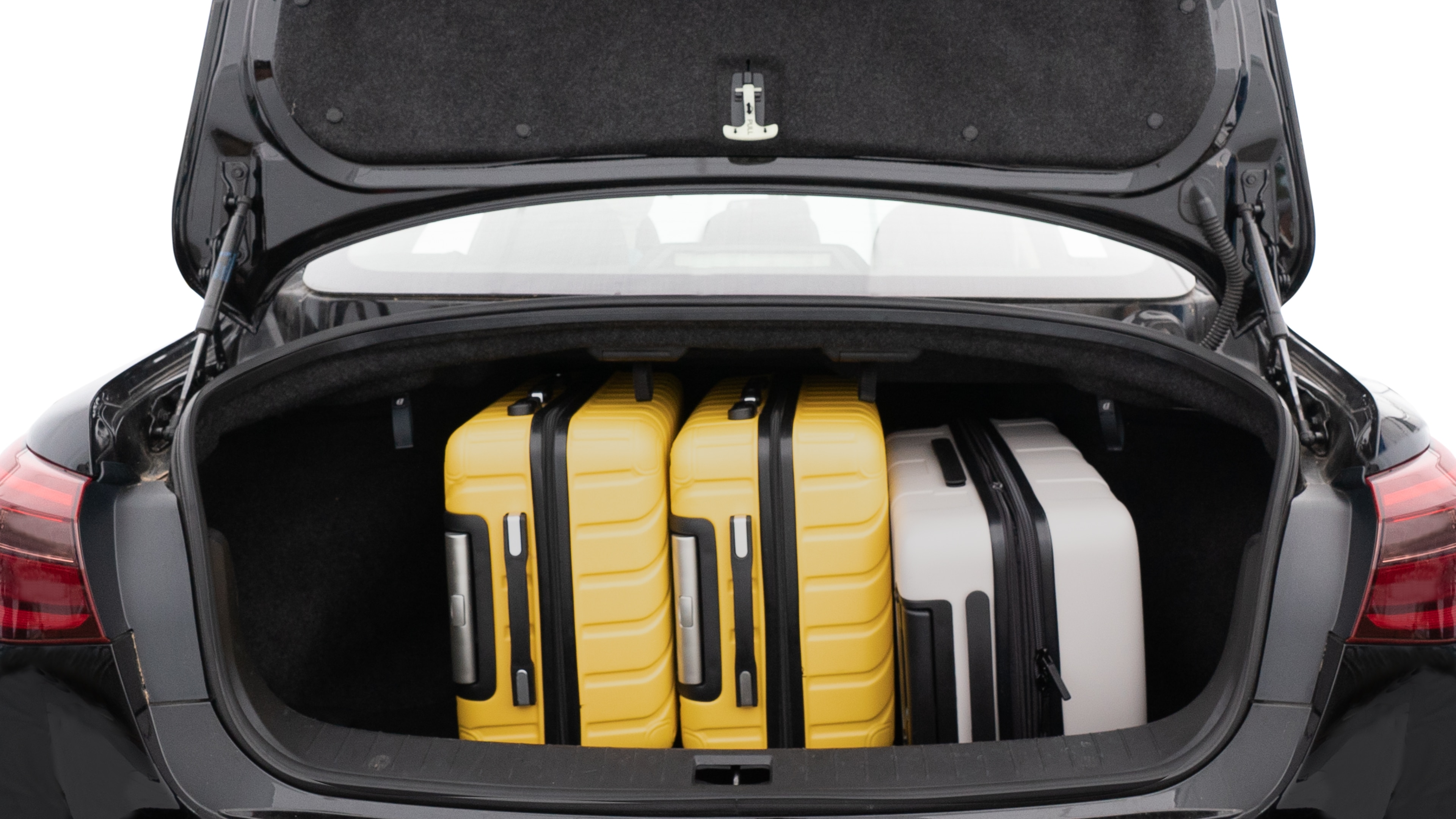 The trunk lid is open, showing full view of the trunk space. Two medium and one small suitcase are placed inside.