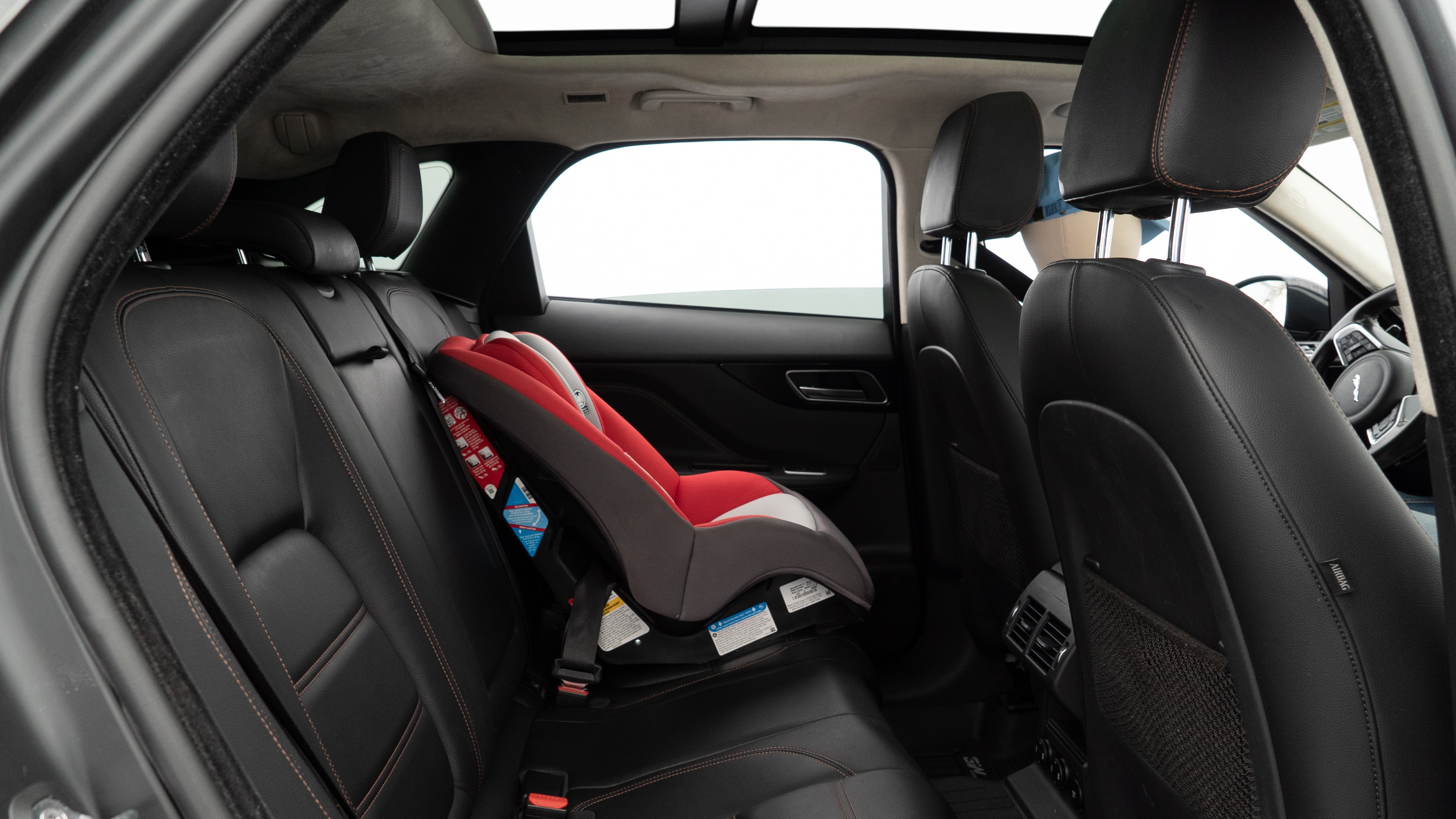 A series of second-row backseat photos is shown including one seating a baby seat and one seating a 6'1" mannequin.