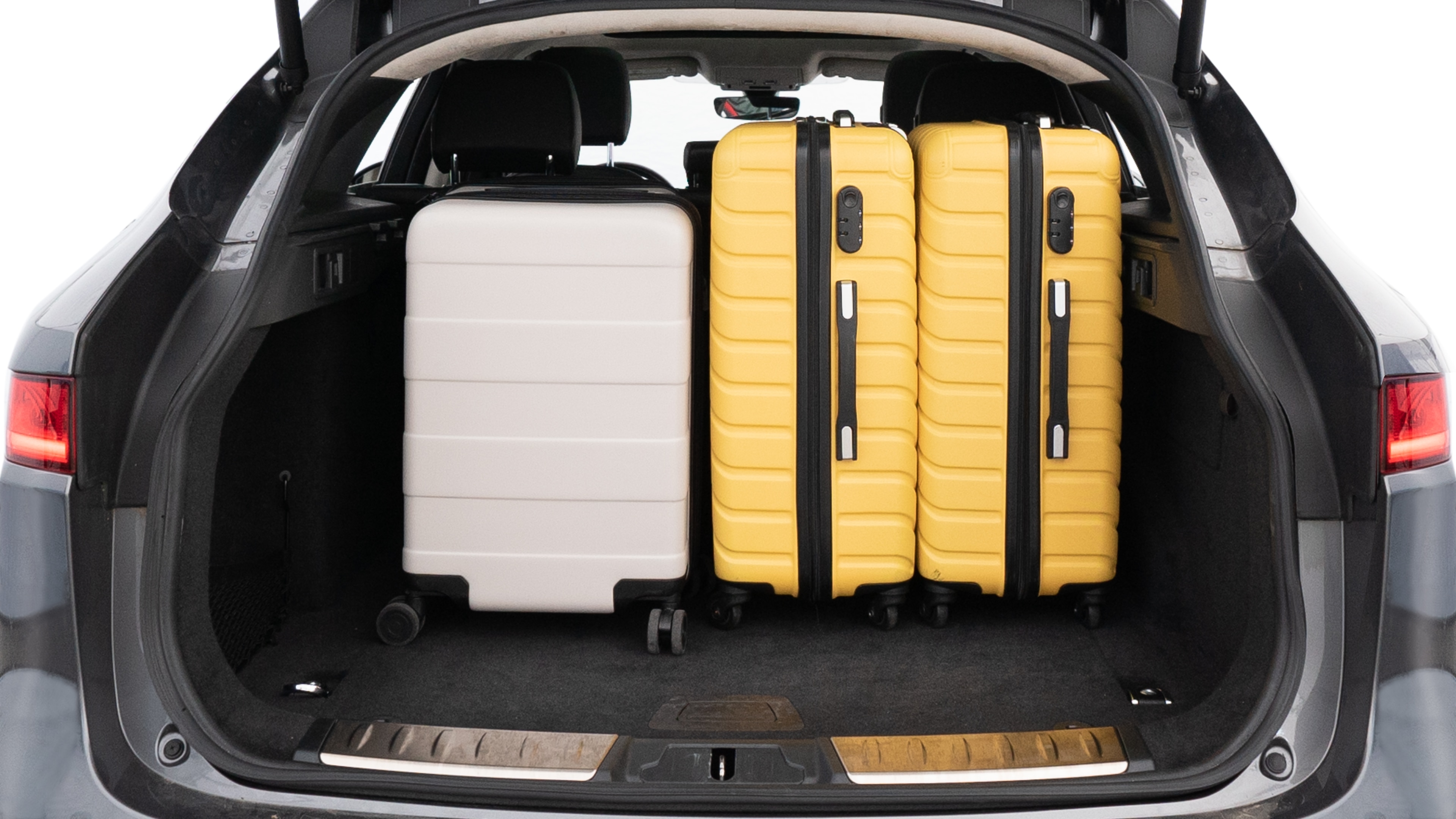 The trunk lid is open, showing full view of the trunk space. Two medium and two small suitcases are placed inside.