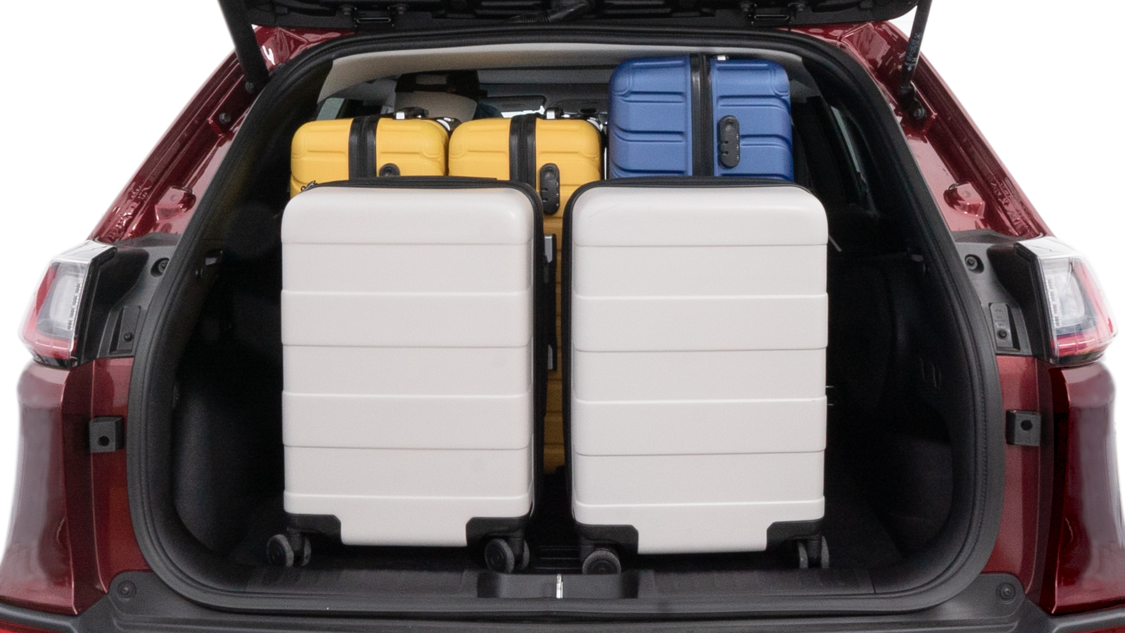 The trunk lid is open, showing full view of the trunk space. One large, two medium and two small suitcases are placed inside.
