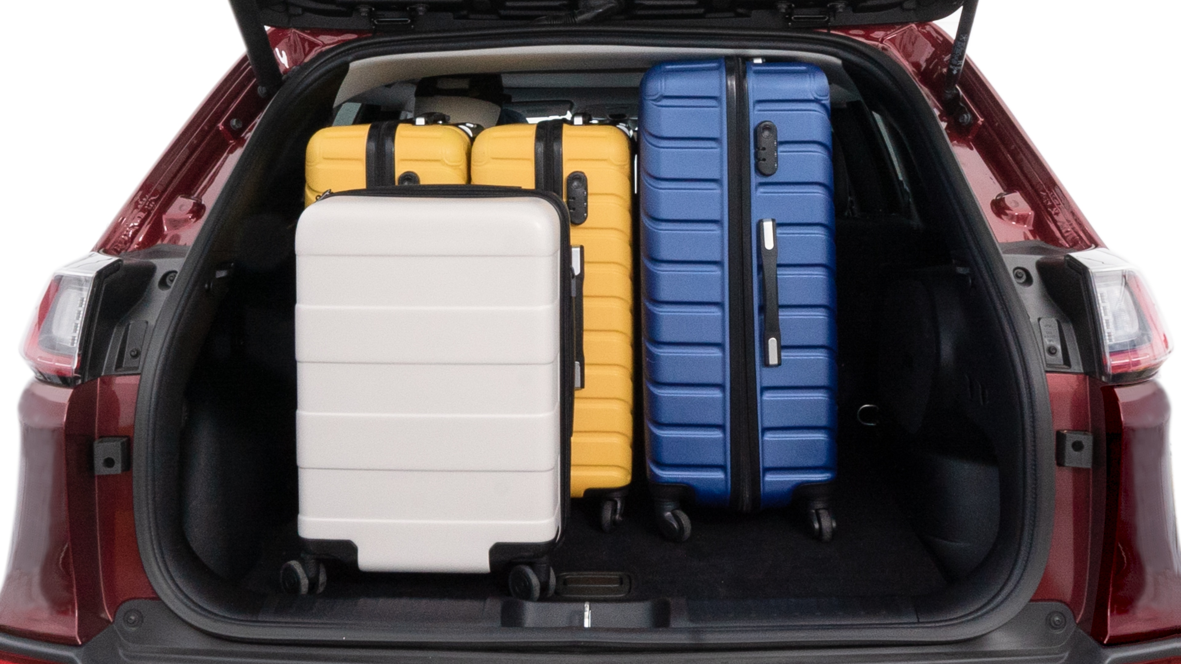 The trunk lid is open, showing full view of the trunk space. One large, two medium and two small suitcases are placed inside.