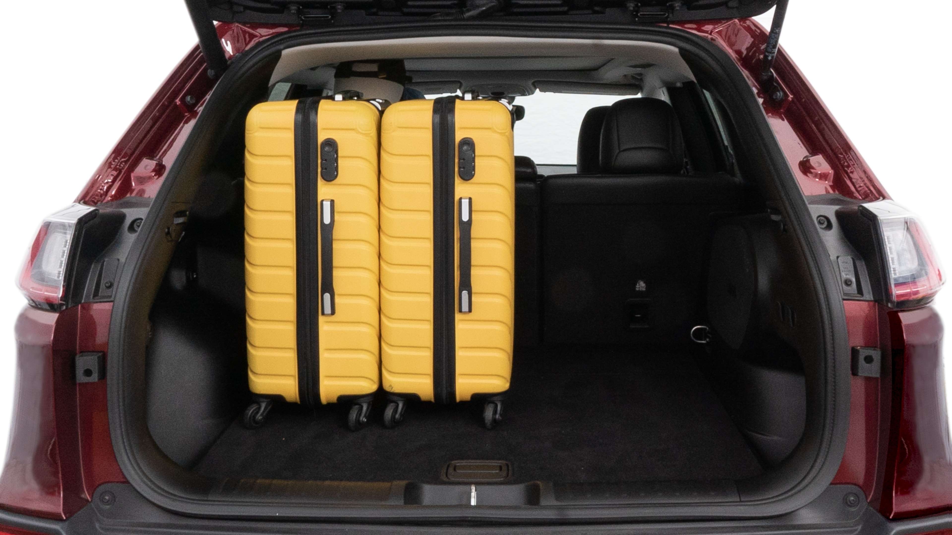 The trunk lid is open, showing full view of the trunk space. One large, two medium and two small suitcases are placed inside.