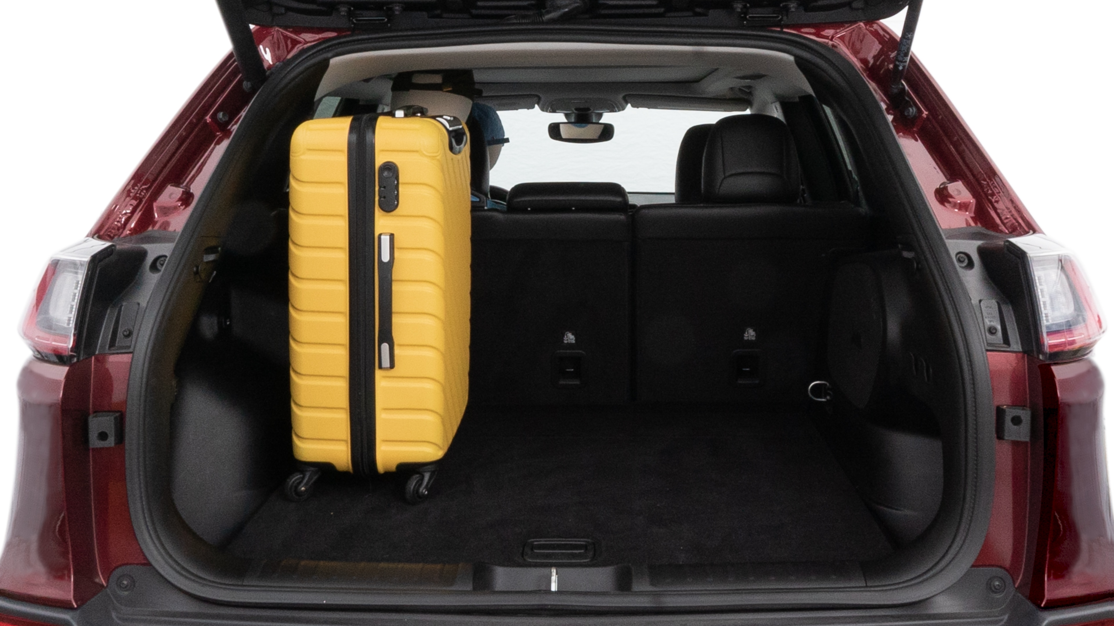 The trunk lid is open, showing full view of the trunk space. One large, two medium and two small suitcases are placed inside.
