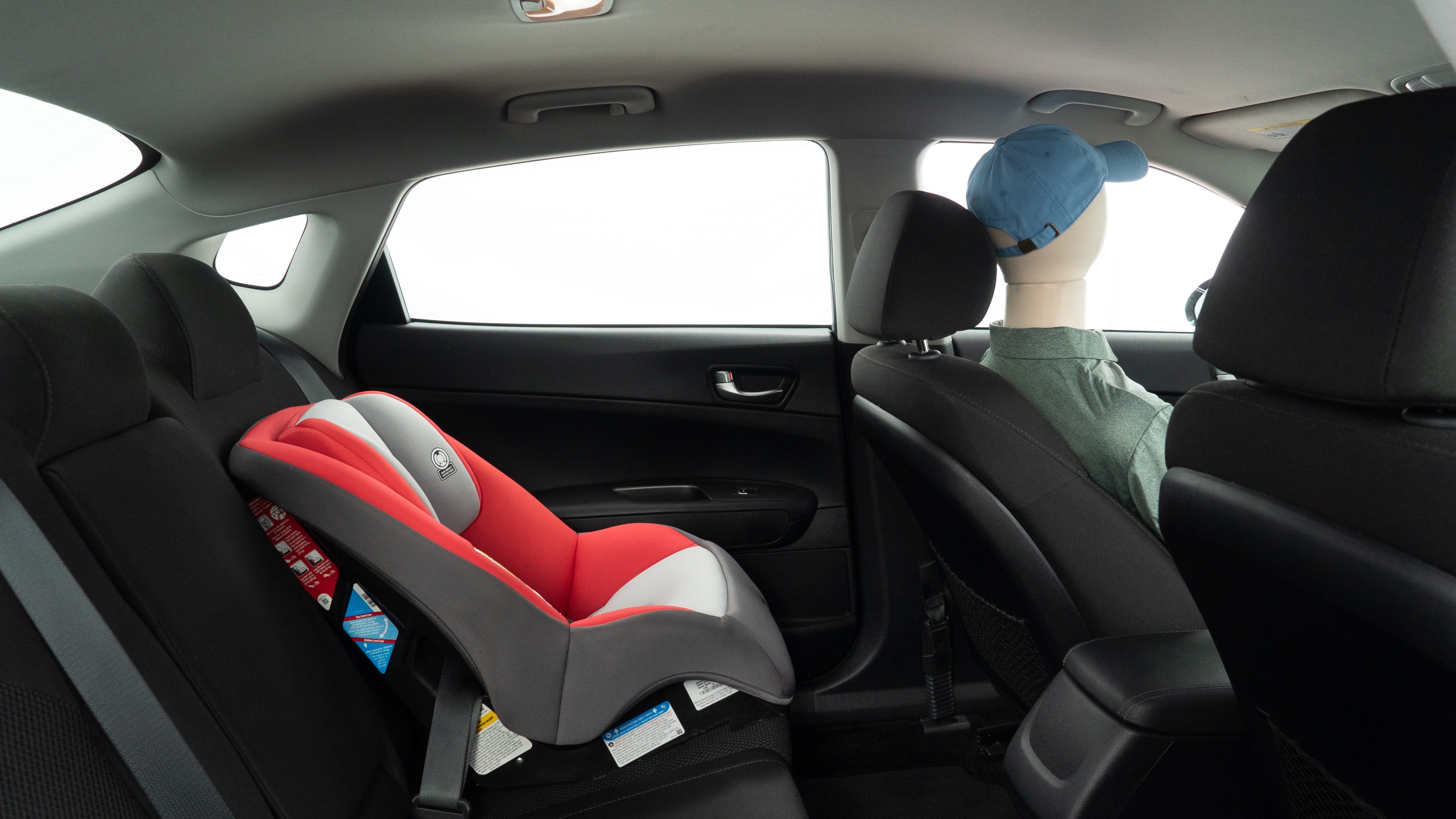 A series of second-row backseat photos is shown including one seating a baby seat and one seating a 6'1" mannequin.