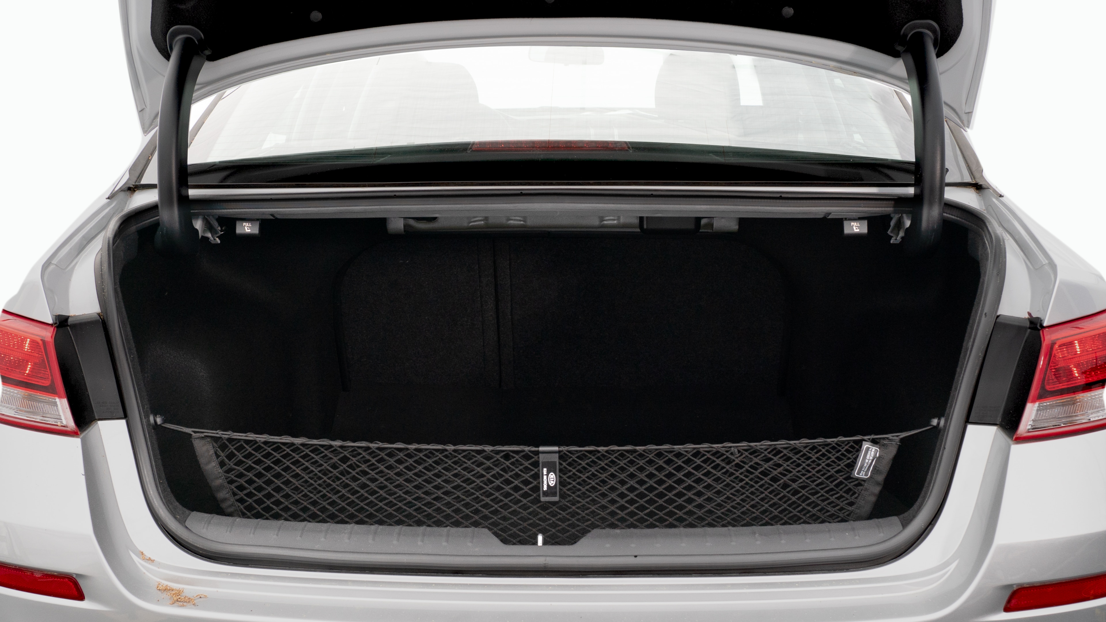 The trunk lid is open showing full view of the trunk. A baby stroller, three grocery carriers, two camping chairs in the carrying bag, and a set of golf clubs are placed inside.