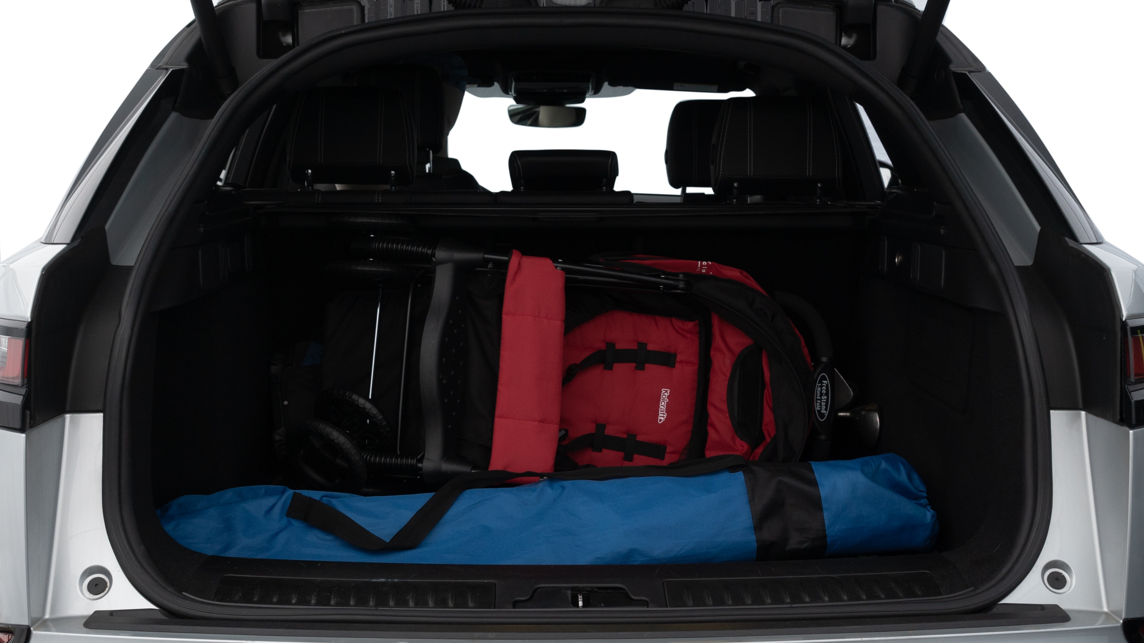 The trunk lid is open showing full view of the trunk. A baby stroller, three grocery carriers, two camping chairs in the carrying bag, and a set of golf clubs are placed inside.