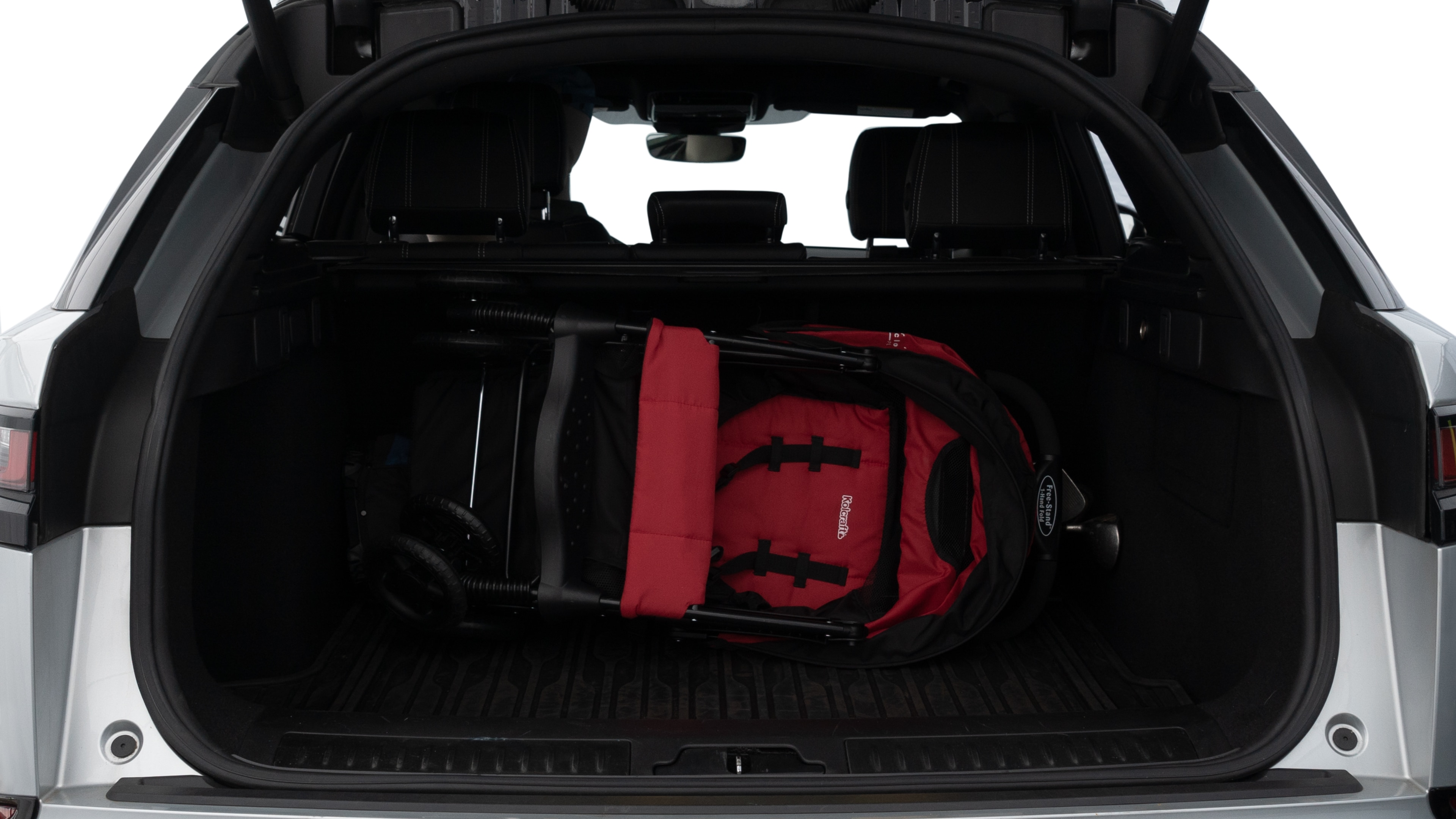 The trunk lid is open showing full view of the trunk. A baby stroller, three grocery carriers, two camping chairs in the carrying bag, and a set of golf clubs are placed inside.