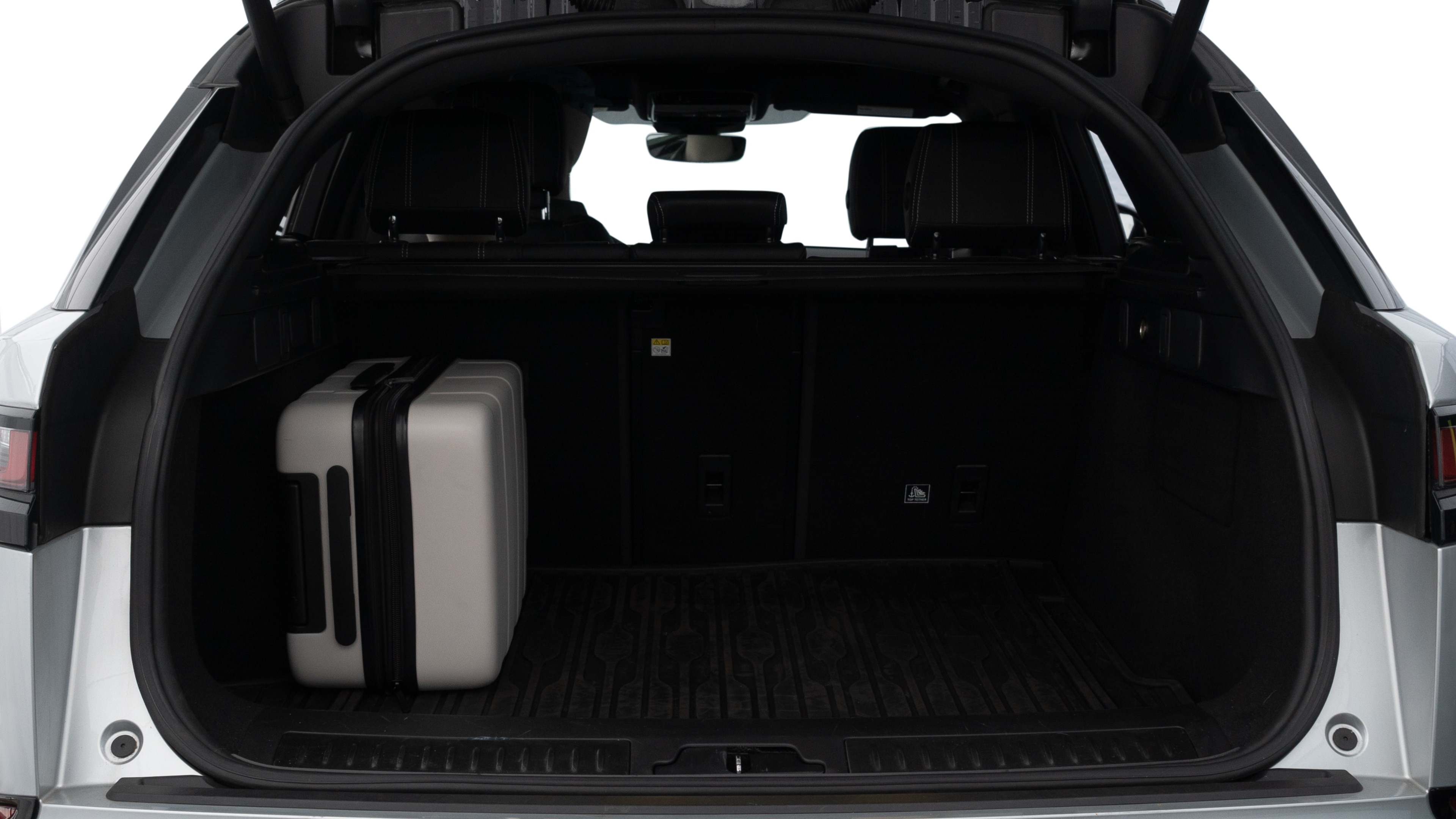 The trunk lid is open, showing full view of the trunk space. Two medium and two small suitcases are placed inside.