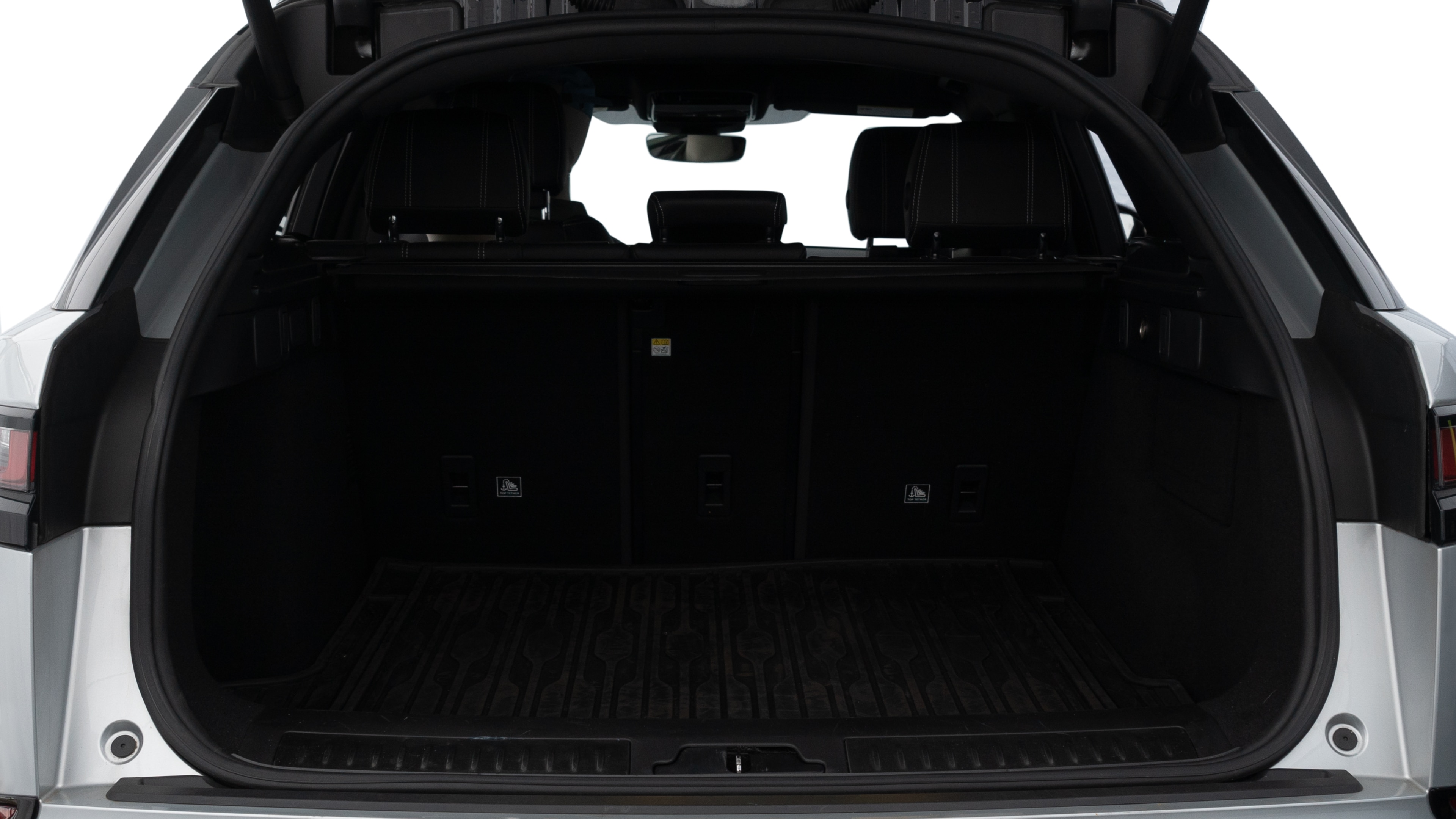 The trunk lid is open, showing full view of the trunk space. Two medium and two small suitcases are placed inside.