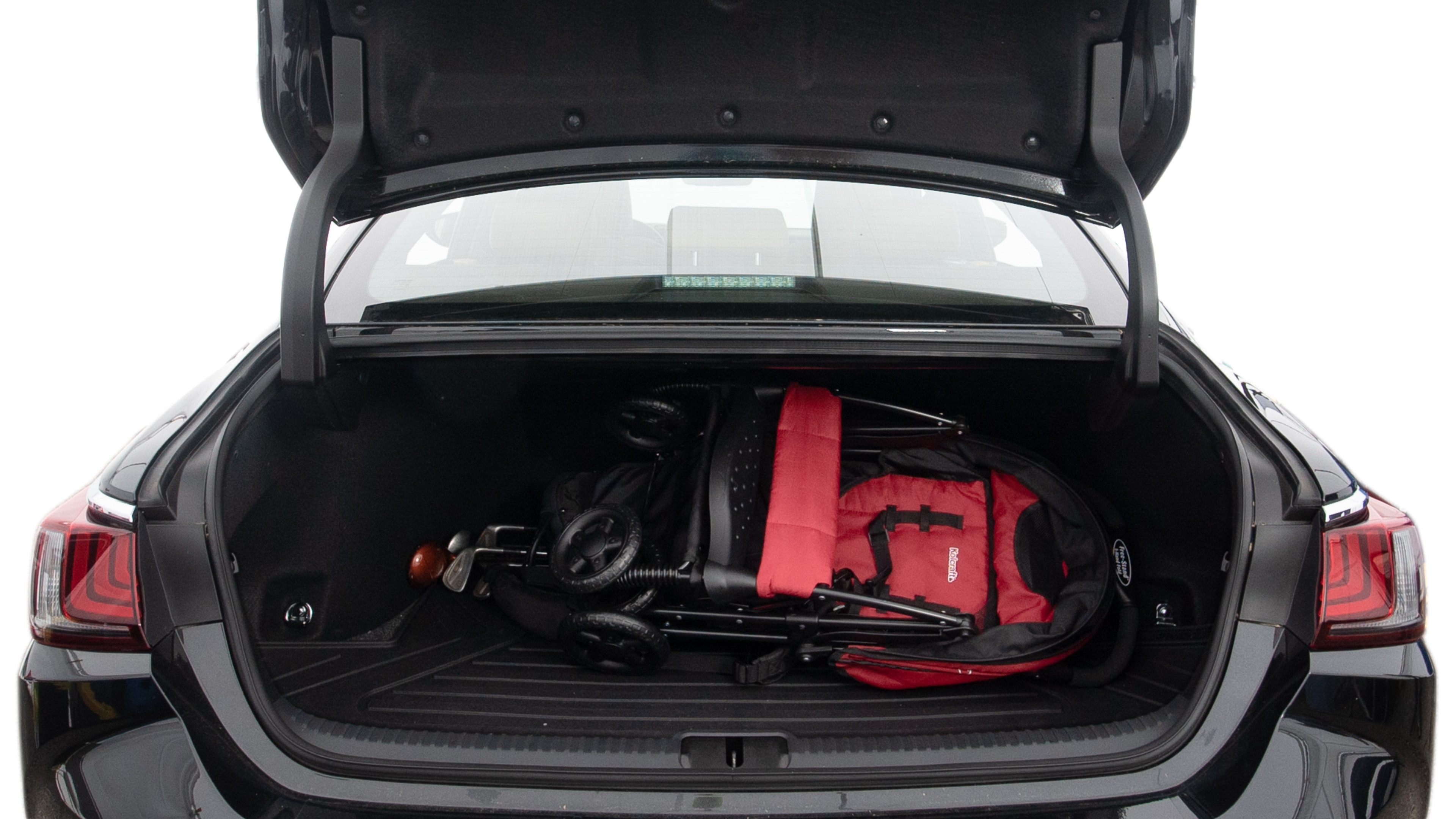 The trunk lid is open showing full view of the trunk. A baby stroller, three grocery carriers, two camping chairs in the carrying bag, and a set of golf clubs are placed inside.
