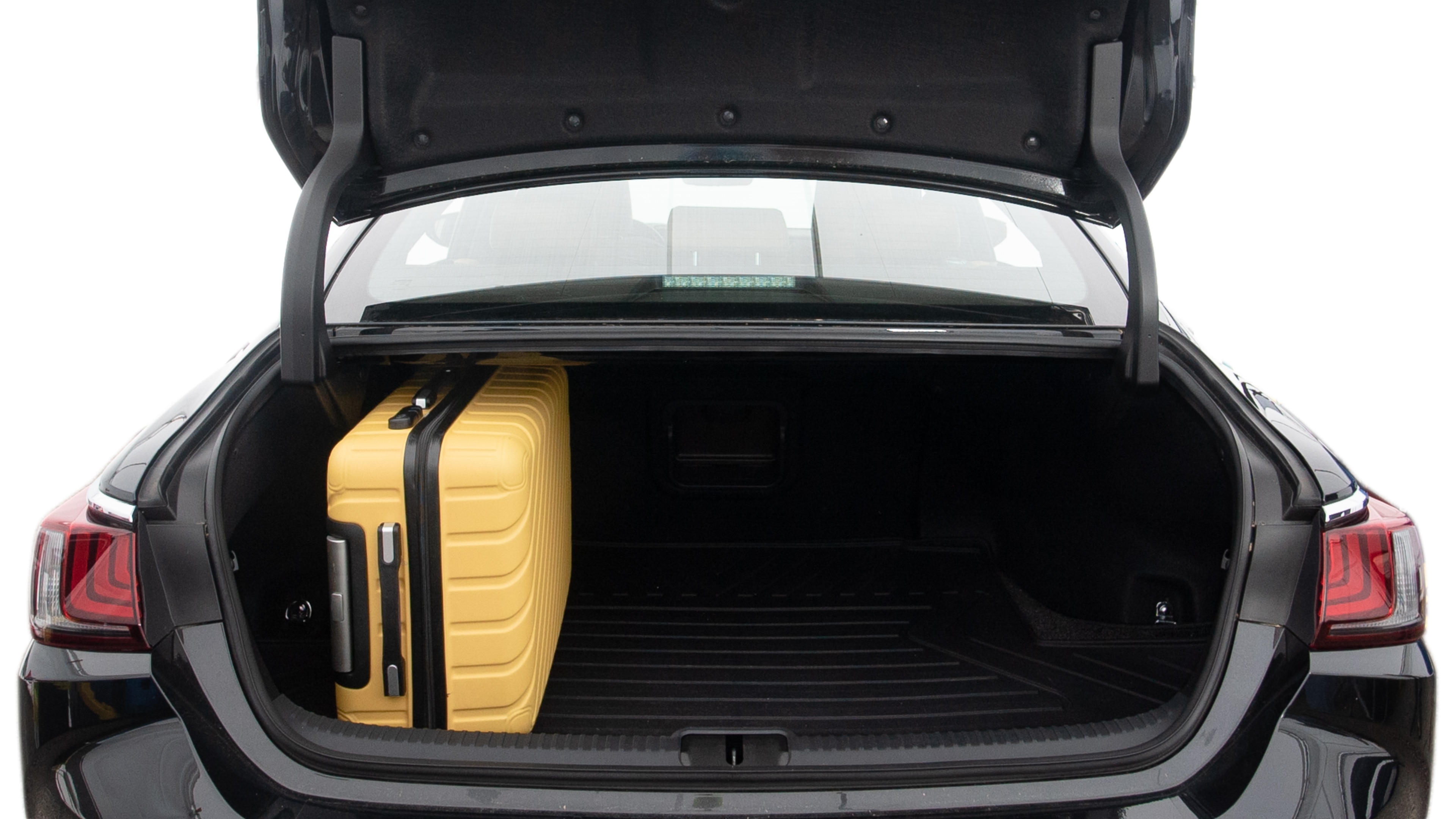 The trunk lid is open, showing full view of the trunk space. Two large and two small suitcases are placed inside.