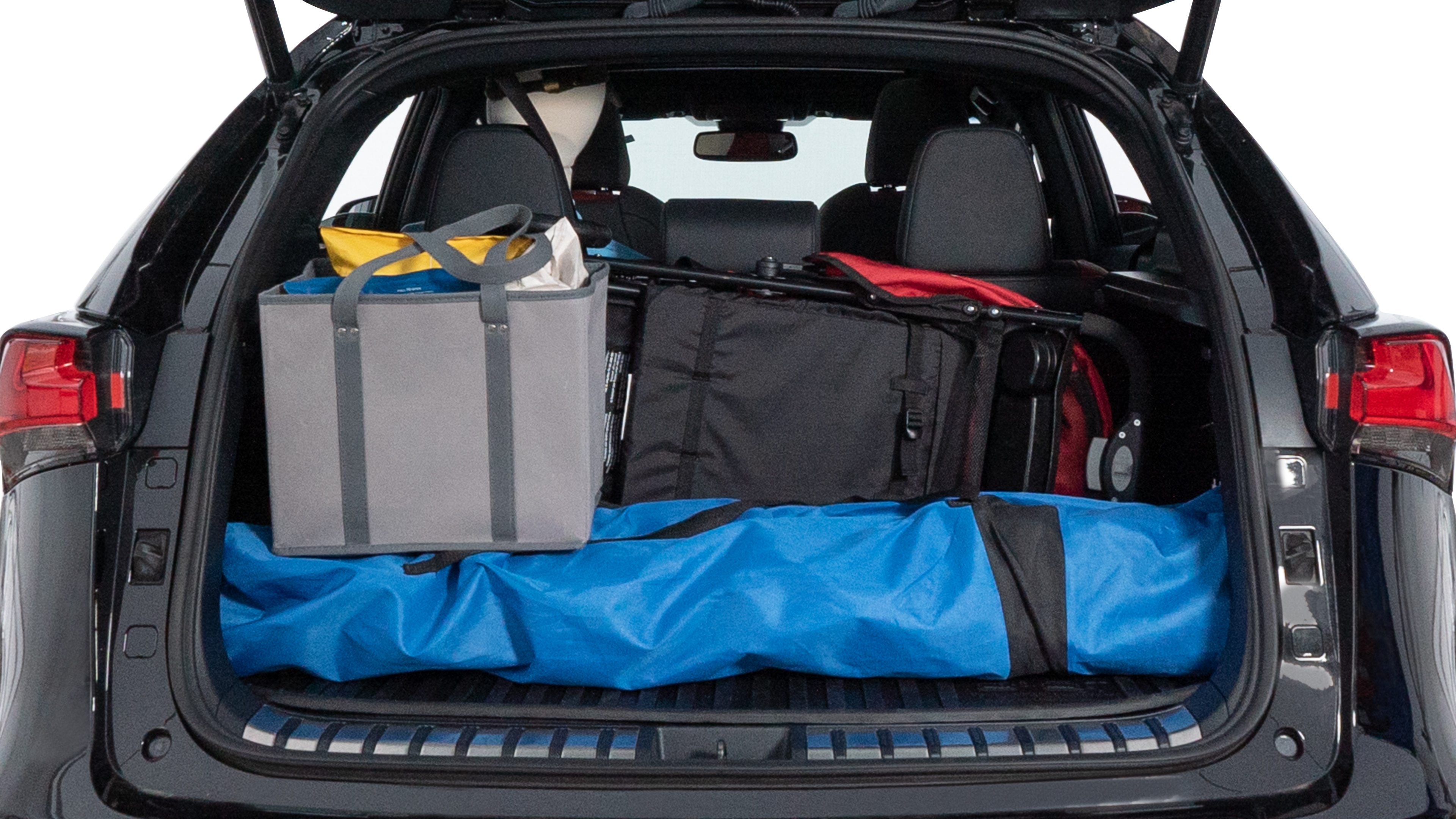 The trunk lid is open showing full view of the trunk. A baby stroller, three grocery carriers, two camping chairs in the carrying bag, and a set of golf clubs are placed inside.