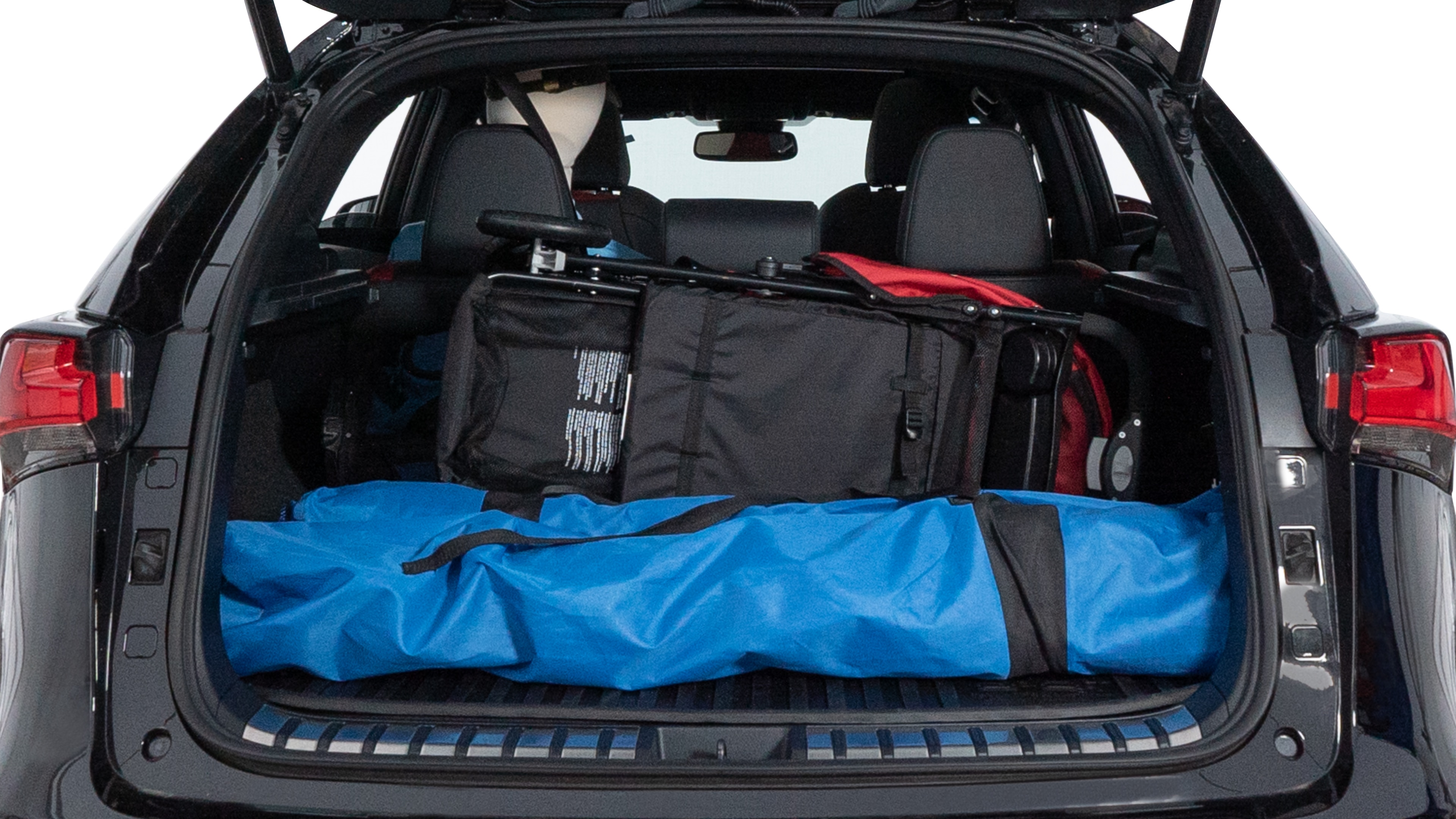 The trunk lid is open showing full view of the trunk. A baby stroller, three grocery carriers, two camping chairs in the carrying bag, and a set of golf clubs are placed inside.