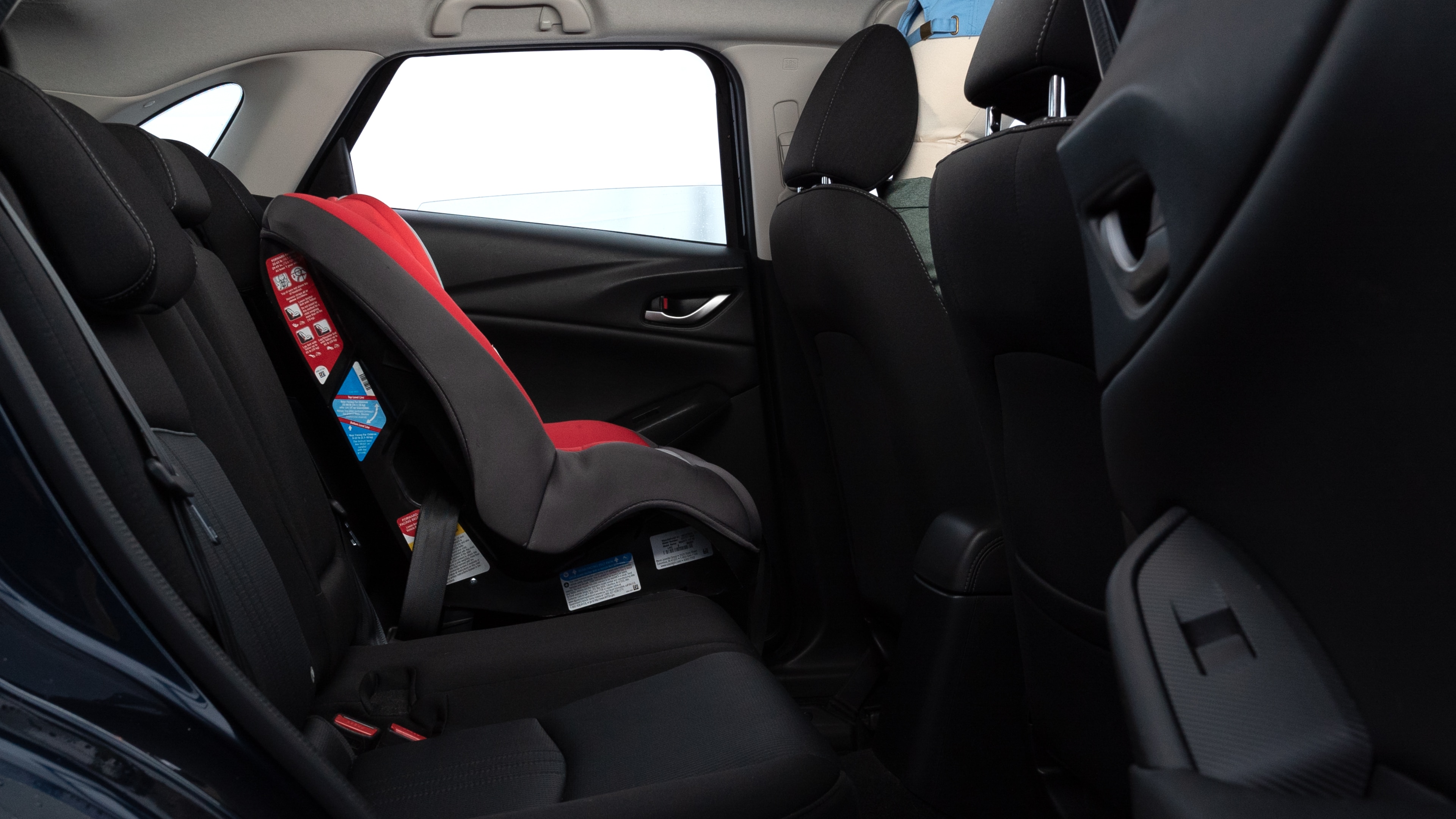 A series of second-row backseat photos is shown including one seating a baby seat and one seating a 6'1" mannequin.