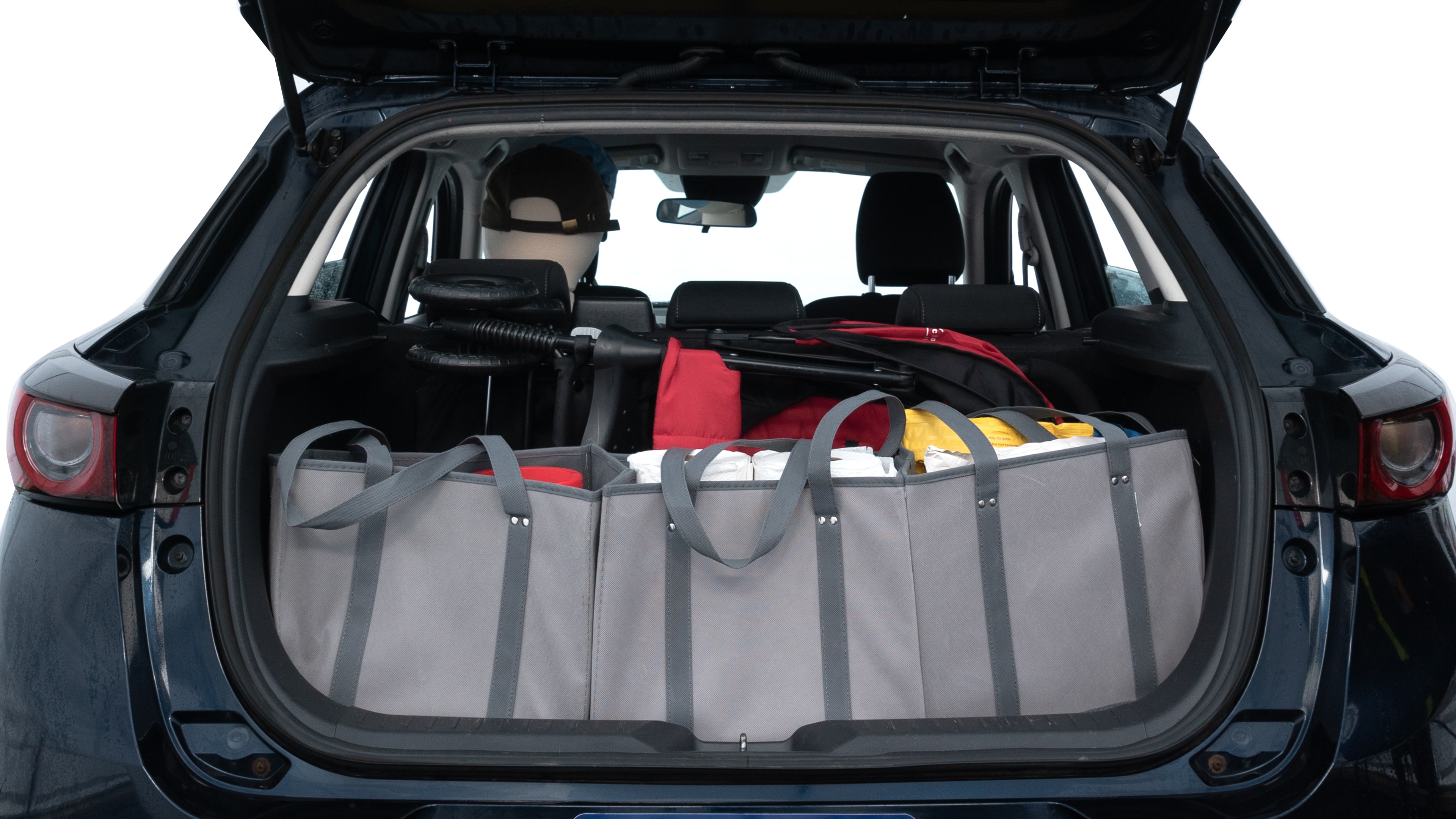The trunk lid is open showing full view of the trunk. A baby stroller, three grocery carriers, two camping chairs in the carrying bag, and a set of golf clubs are placed inside.
