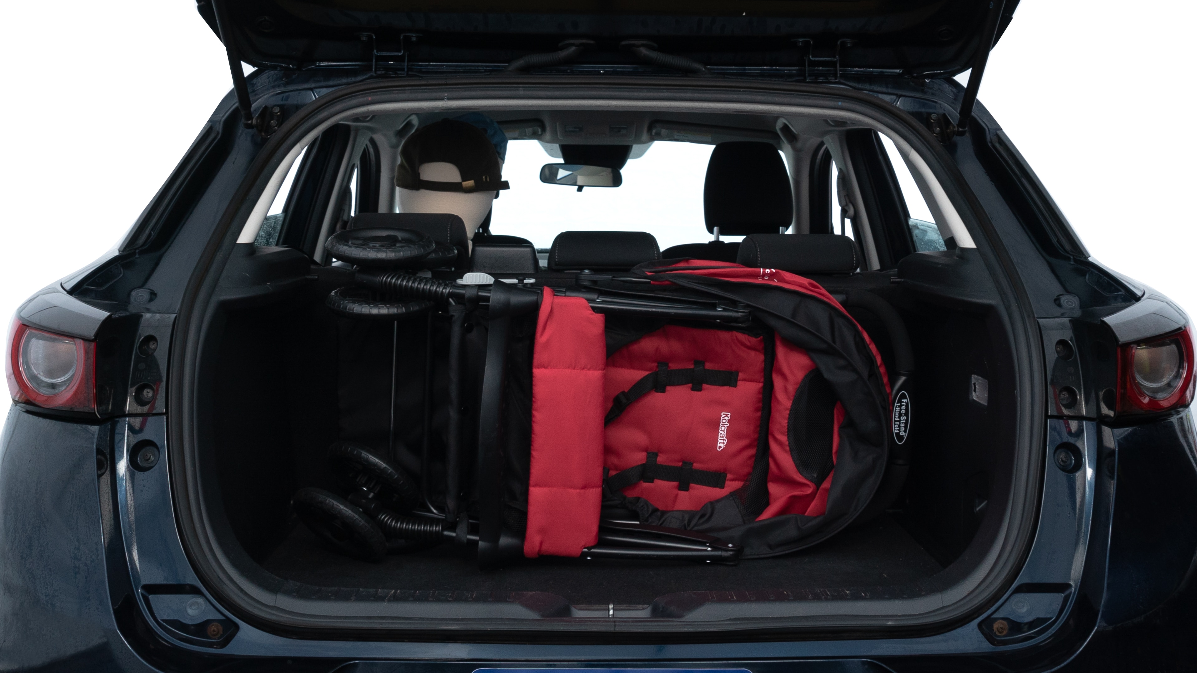 The trunk lid is open showing full view of the trunk. A baby stroller, three grocery carriers, two camping chairs in the carrying bag, and a set of golf clubs are placed inside.