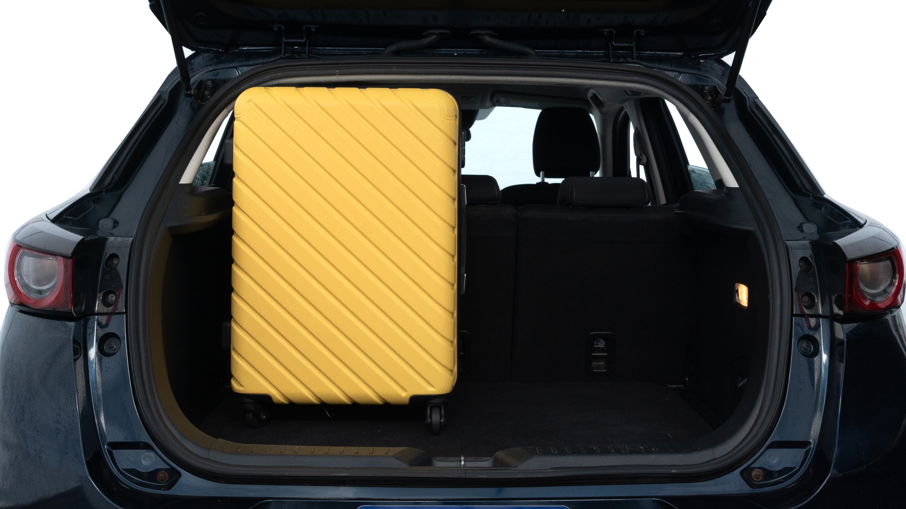 The trunk lid is open, showing full view of the trunk space. Two medium and one small suitcases are placed inside.
