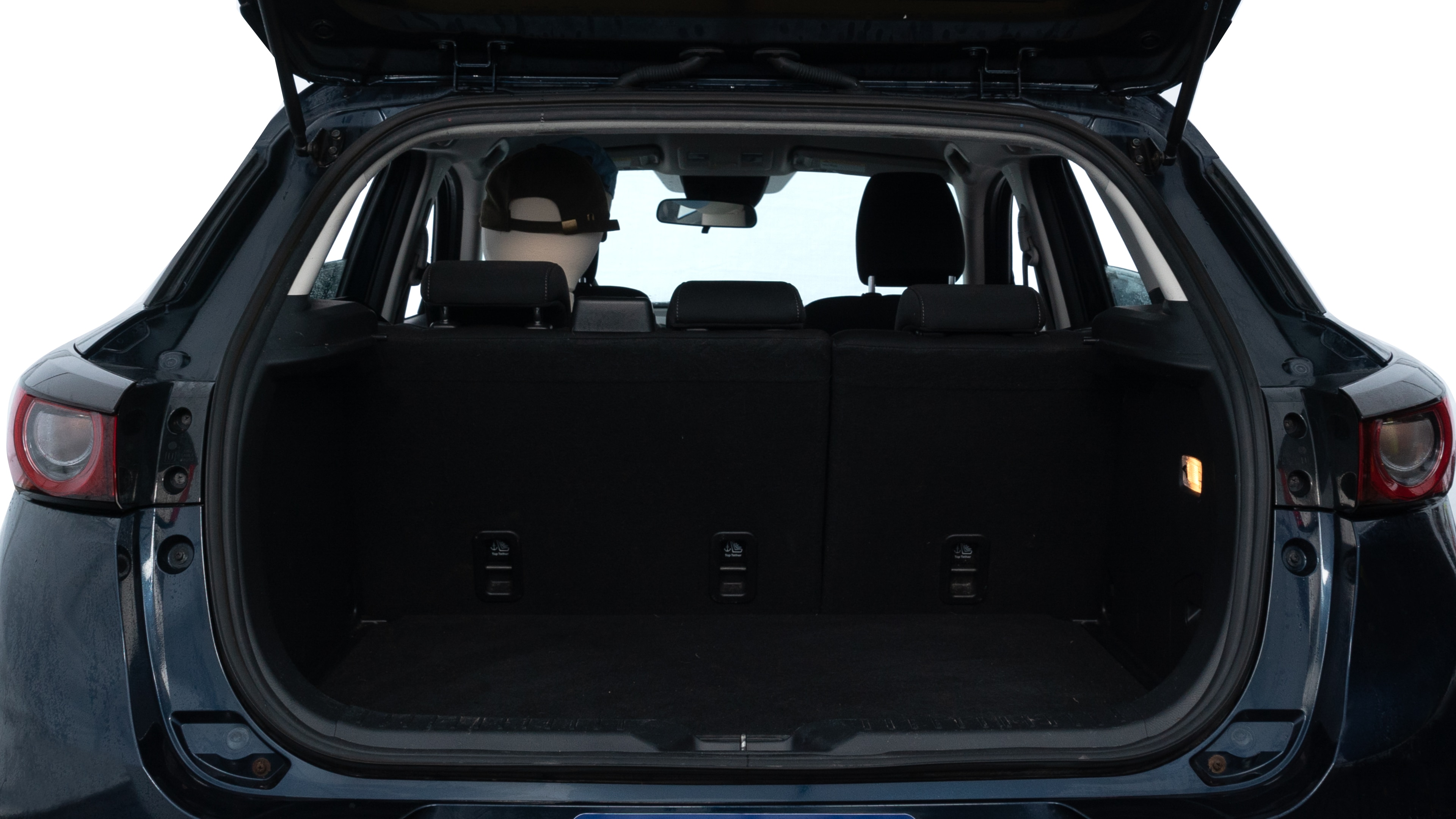 The trunk lid is open, showing full view of the trunk space. Two medium and one small suitcases are placed inside.
