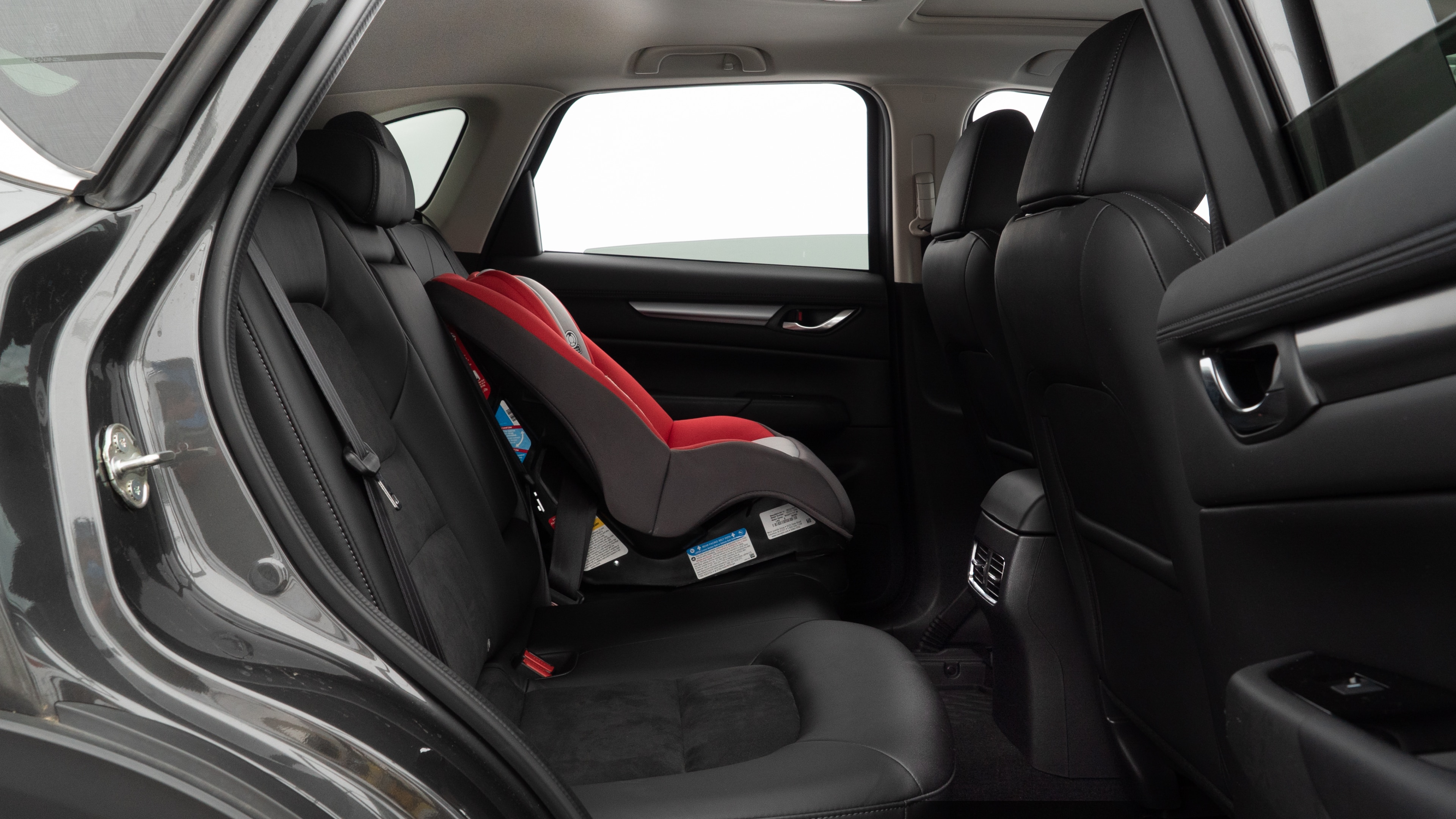 A series of second-row backseat photos is shown including one seating a baby seat and one seating a 6'1" mannequin.