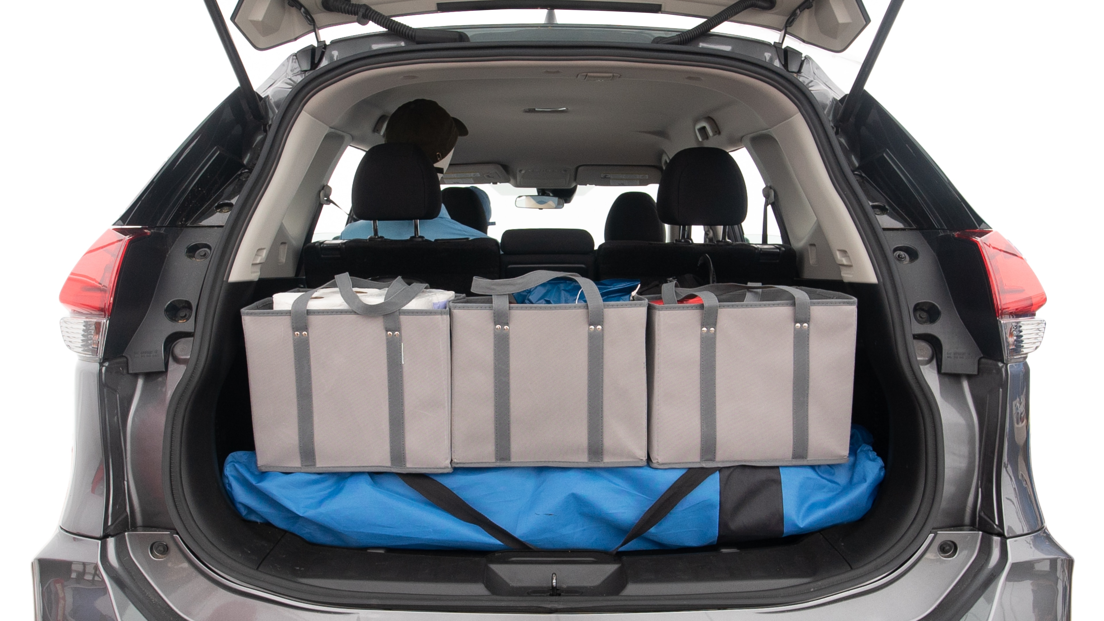The trunk lid is open showing full view of the trunk. A baby stroller, three grocery carriers, two camping chairs in the carrying bag, and a set of golf clubs are placed inside.