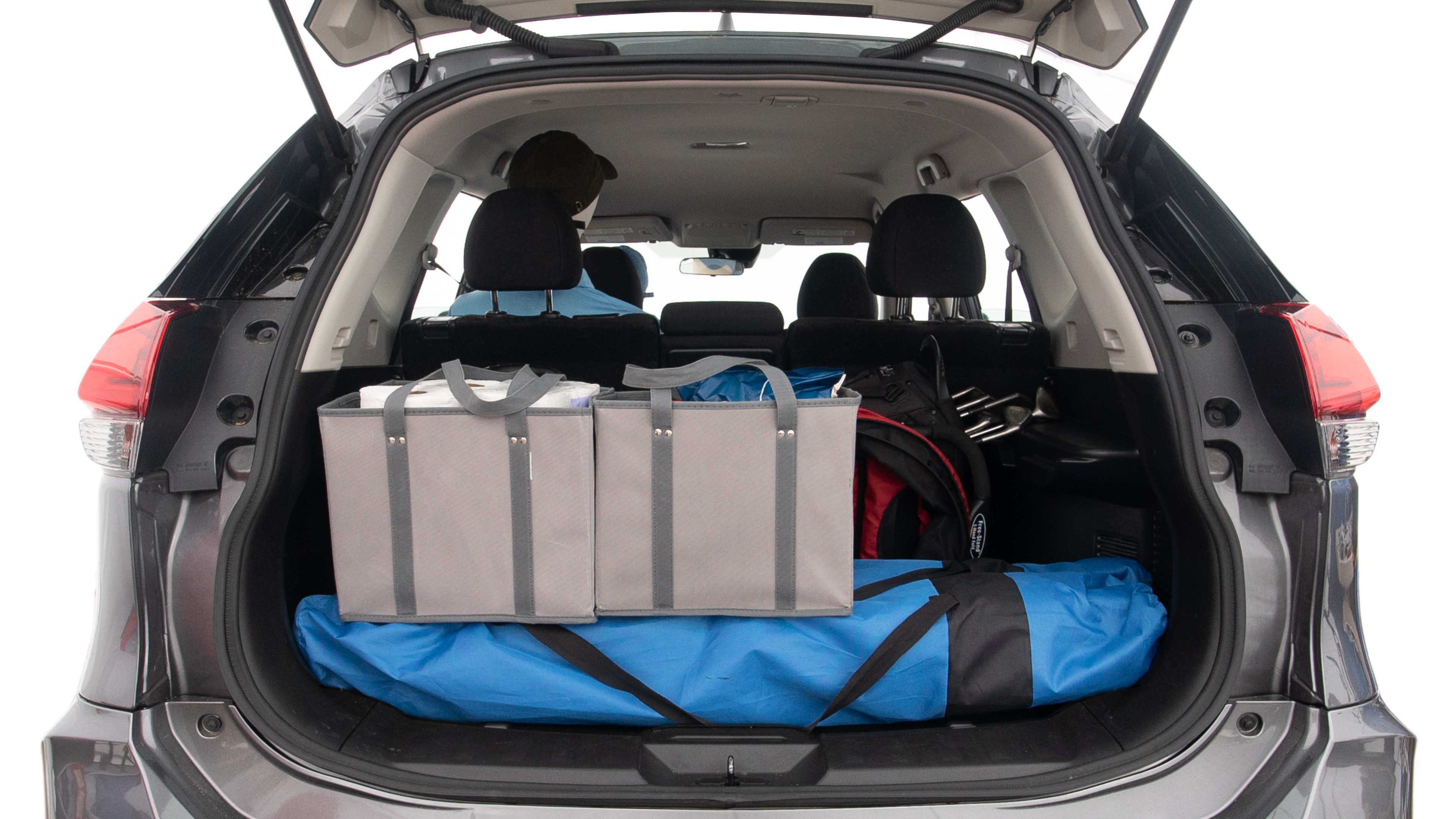 The trunk lid is open showing full view of the trunk. A baby stroller, three grocery carriers, two camping chairs in the carrying bag, and a set of golf clubs are placed inside.