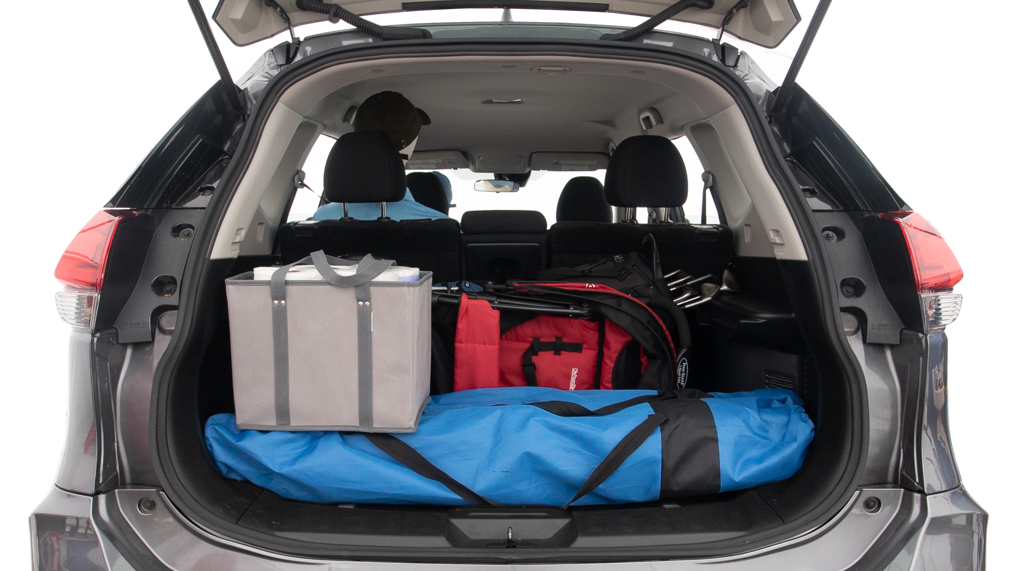 The trunk lid is open showing full view of the trunk. A baby stroller, three grocery carriers, two camping chairs in the carrying bag, and a set of golf clubs are placed inside.