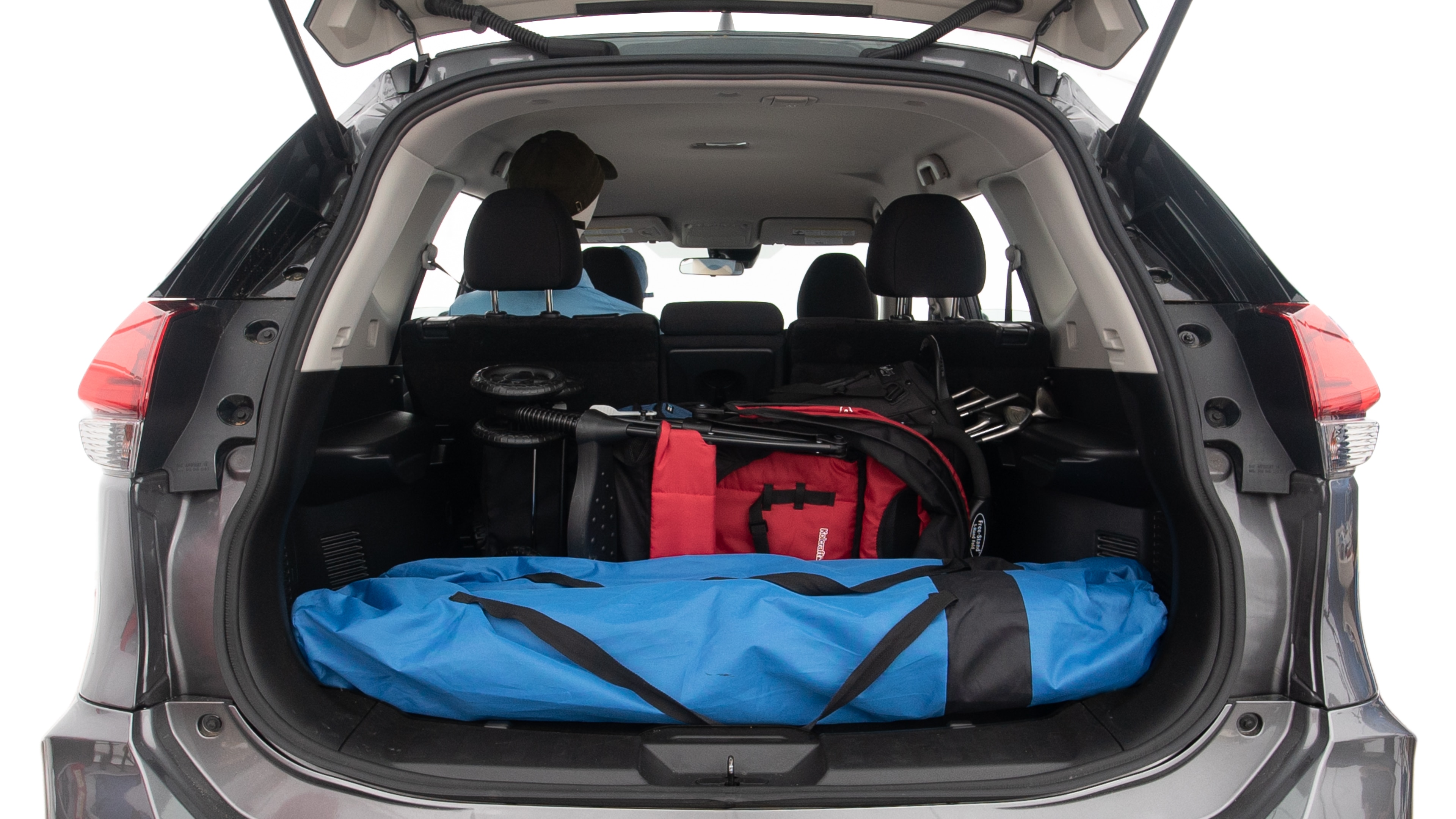 The trunk lid is open showing full view of the trunk. A baby stroller, three grocery carriers, two camping chairs in the carrying bag, and a set of golf clubs are placed inside.