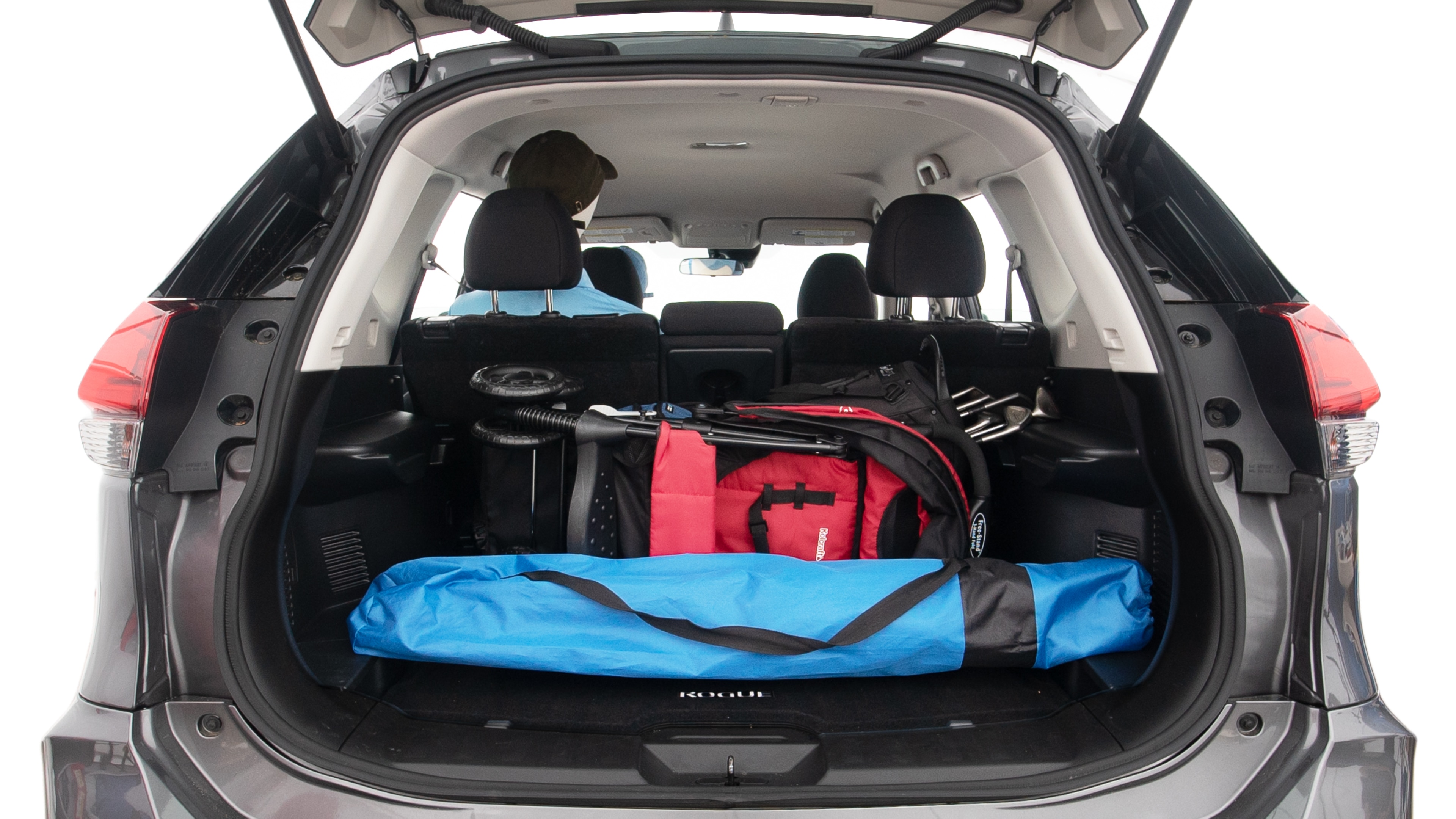 The trunk lid is open showing full view of the trunk. A baby stroller, three grocery carriers, two camping chairs in the carrying bag, and a set of golf clubs are placed inside.