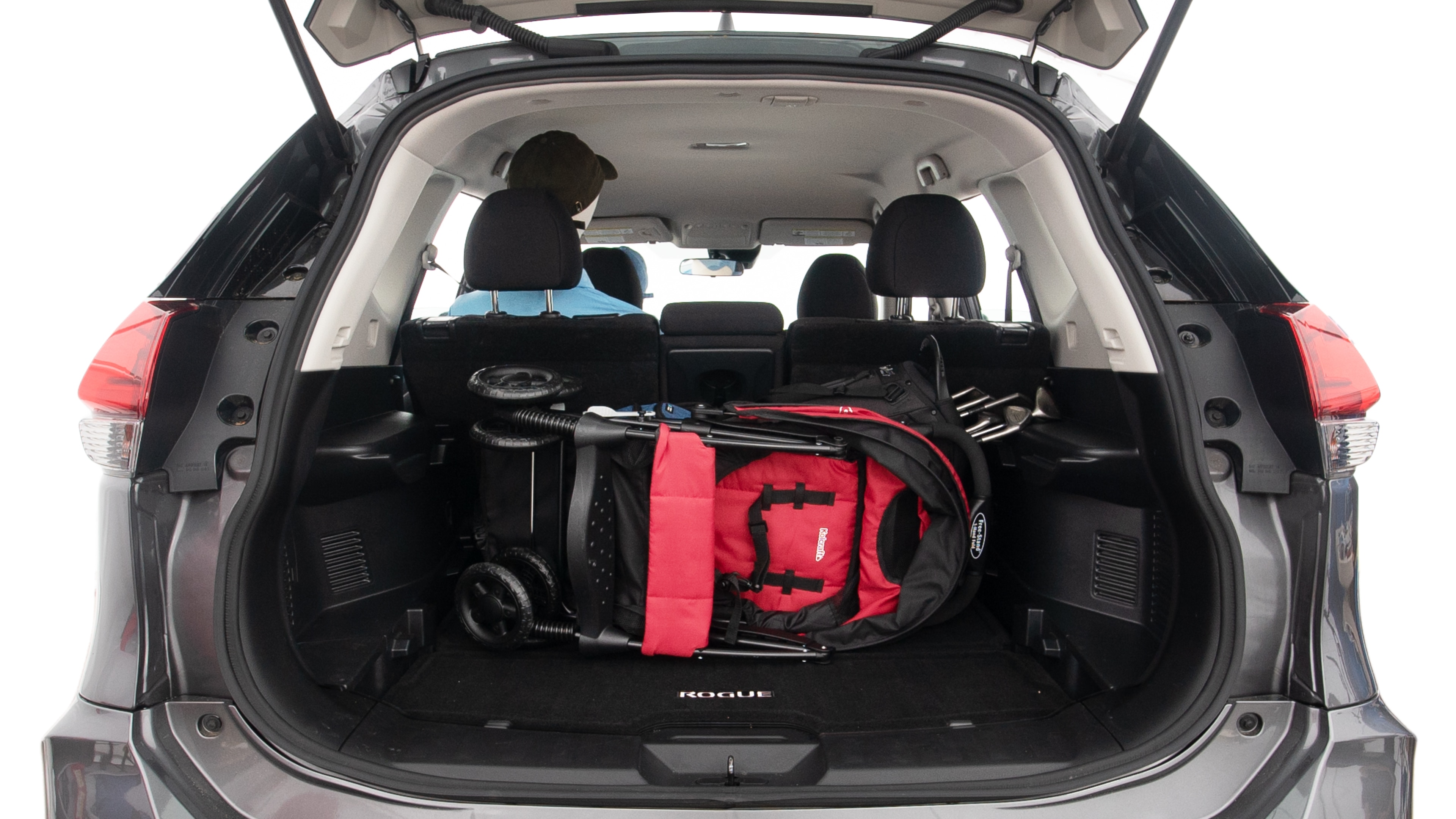 The trunk lid is open showing full view of the trunk. A baby stroller, three grocery carriers, two camping chairs in the carrying bag, and a set of golf clubs are placed inside.