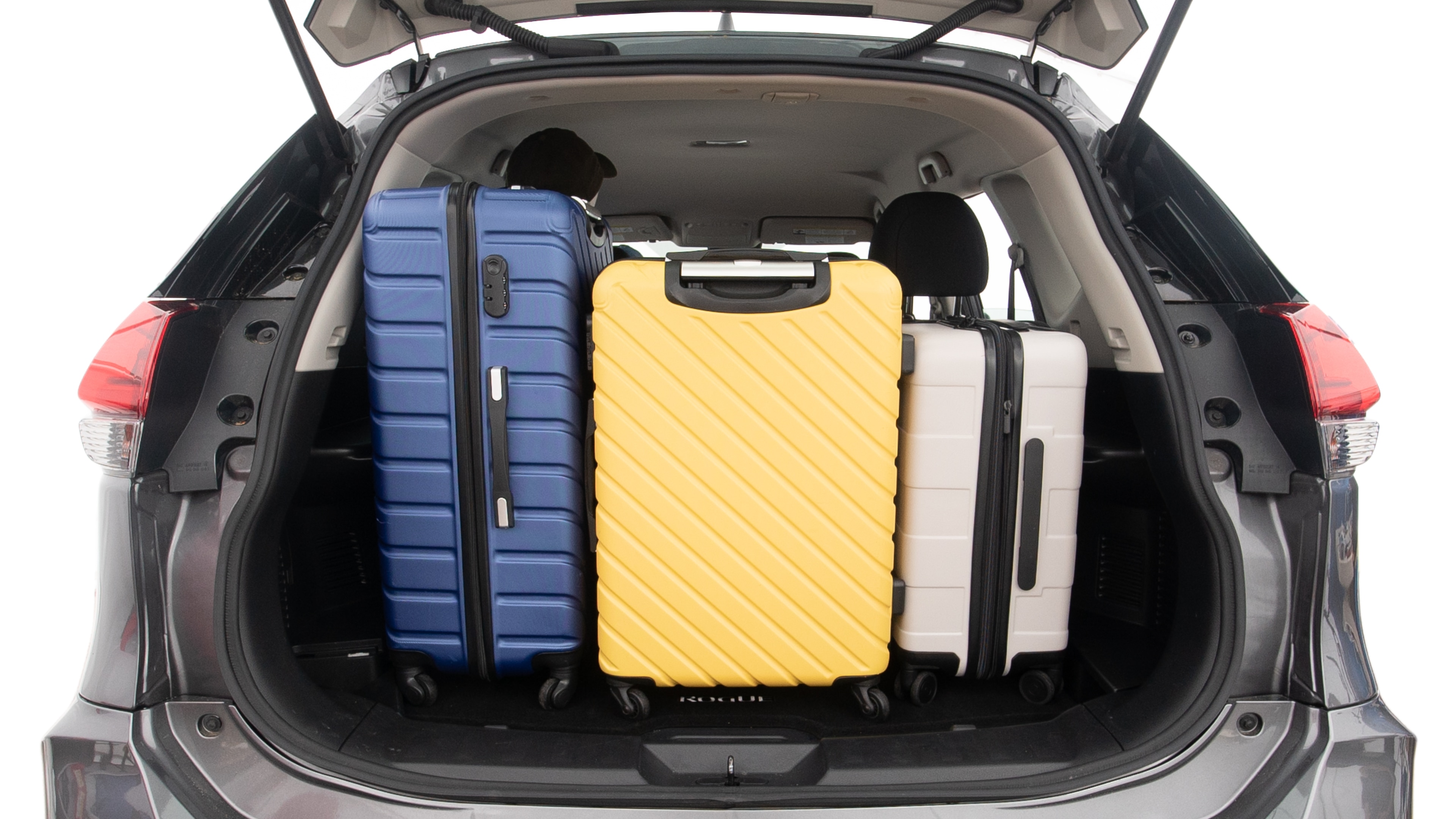 The trunk lid is open, showing full view of the trunk space. One extra large suitcase, two large suitcases and one small suitcases are placed inside.
