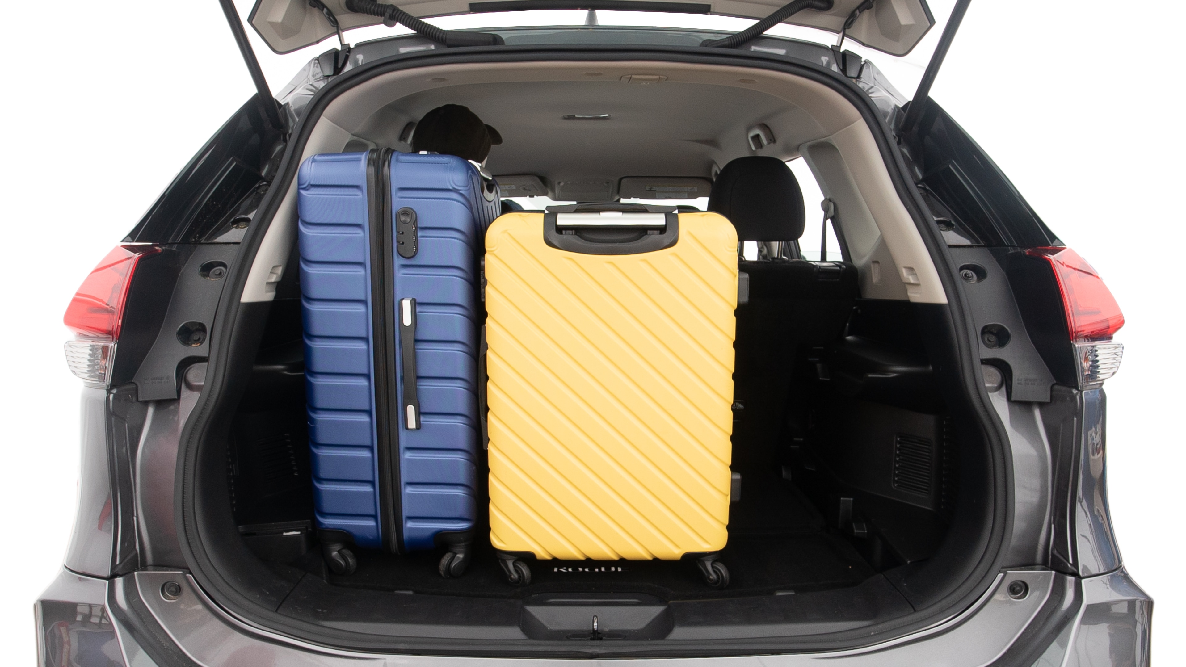 The trunk lid is open, showing full view of the trunk space. One extra large suitcase, two large suitcases and one small suitcases are placed inside.
