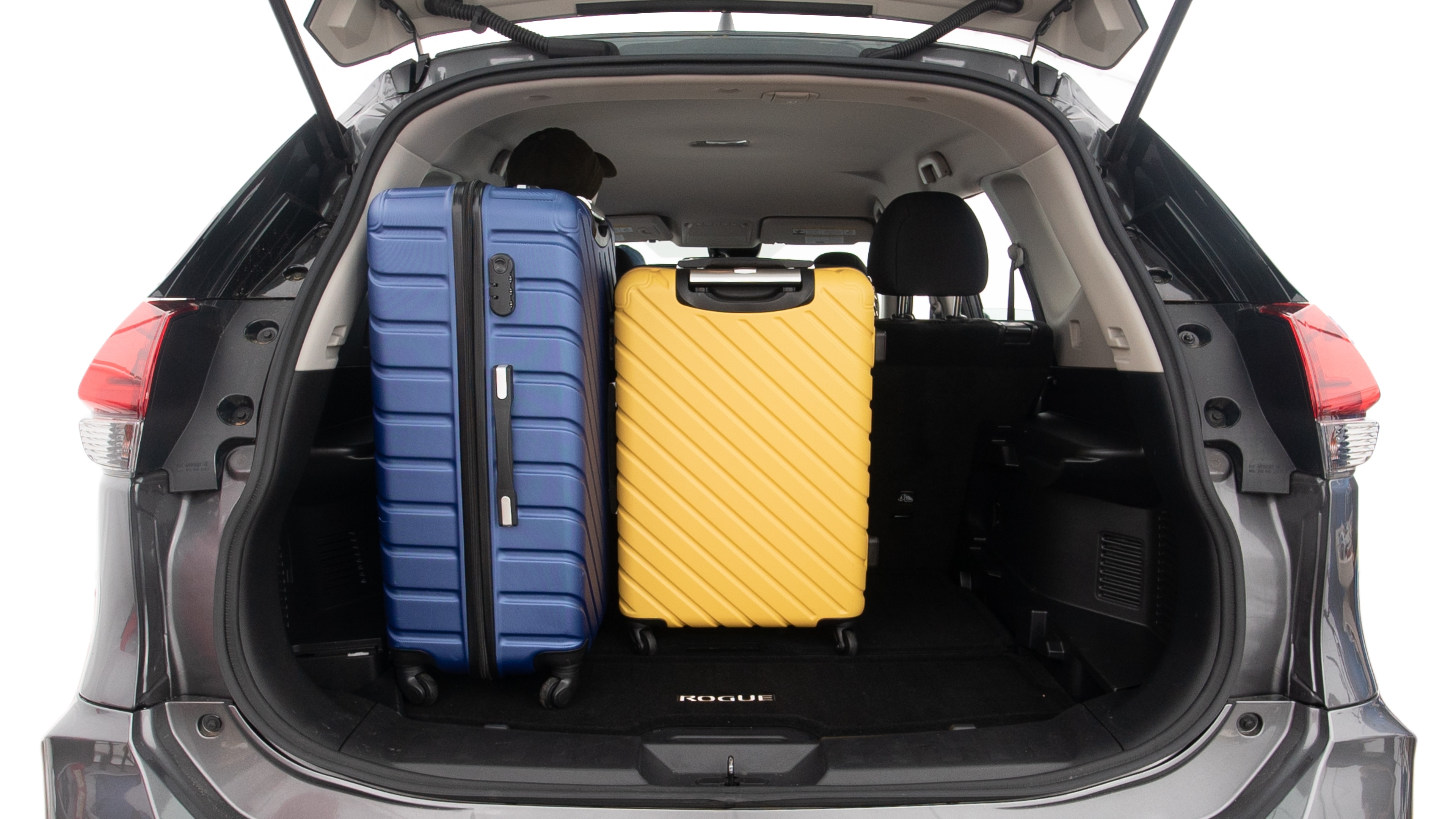 The trunk lid is open, showing full view of the trunk space. One extra large suitcase, two large suitcases and one small suitcases are placed inside.
