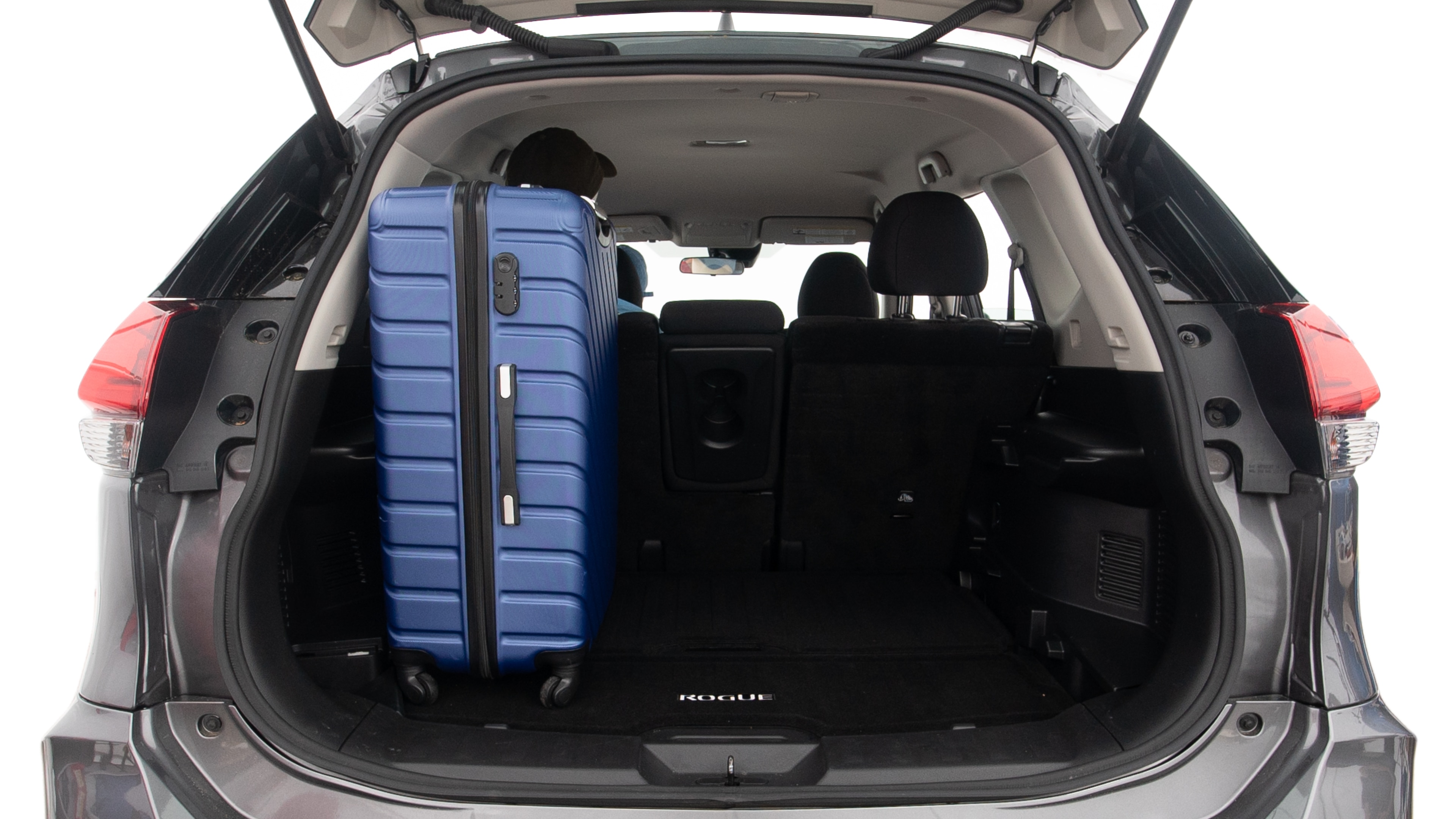 The trunk lid is open, showing full view of the trunk space. One extra large suitcase, two large suitcases and one small suitcases are placed inside.