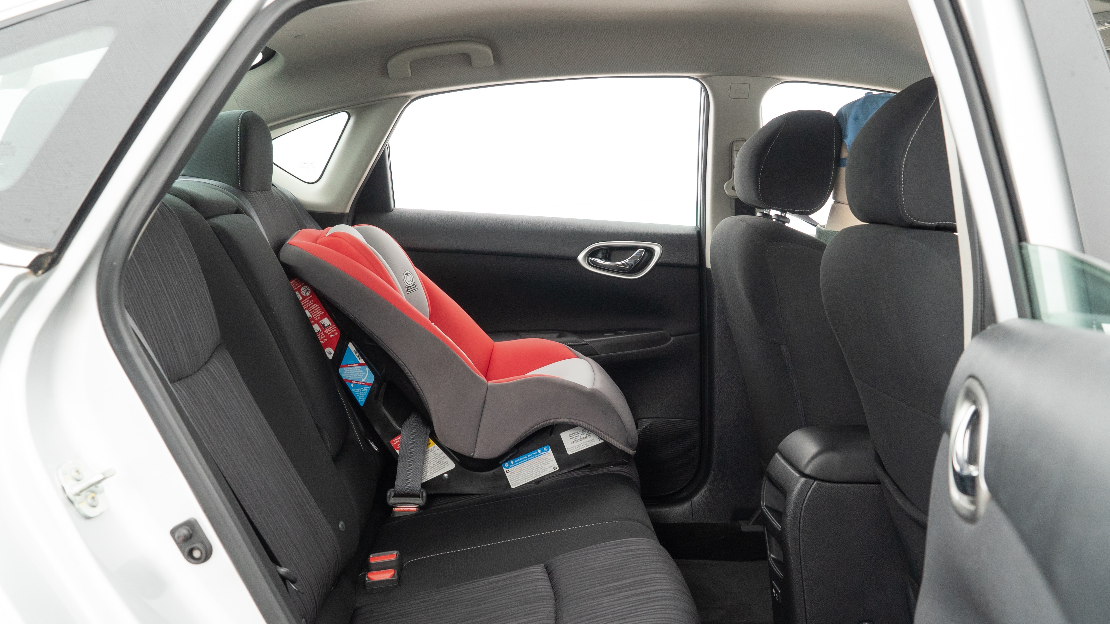 A series of second-row backseat photos is shown including one seating a baby seat and one seating a 6'1" mannequin.