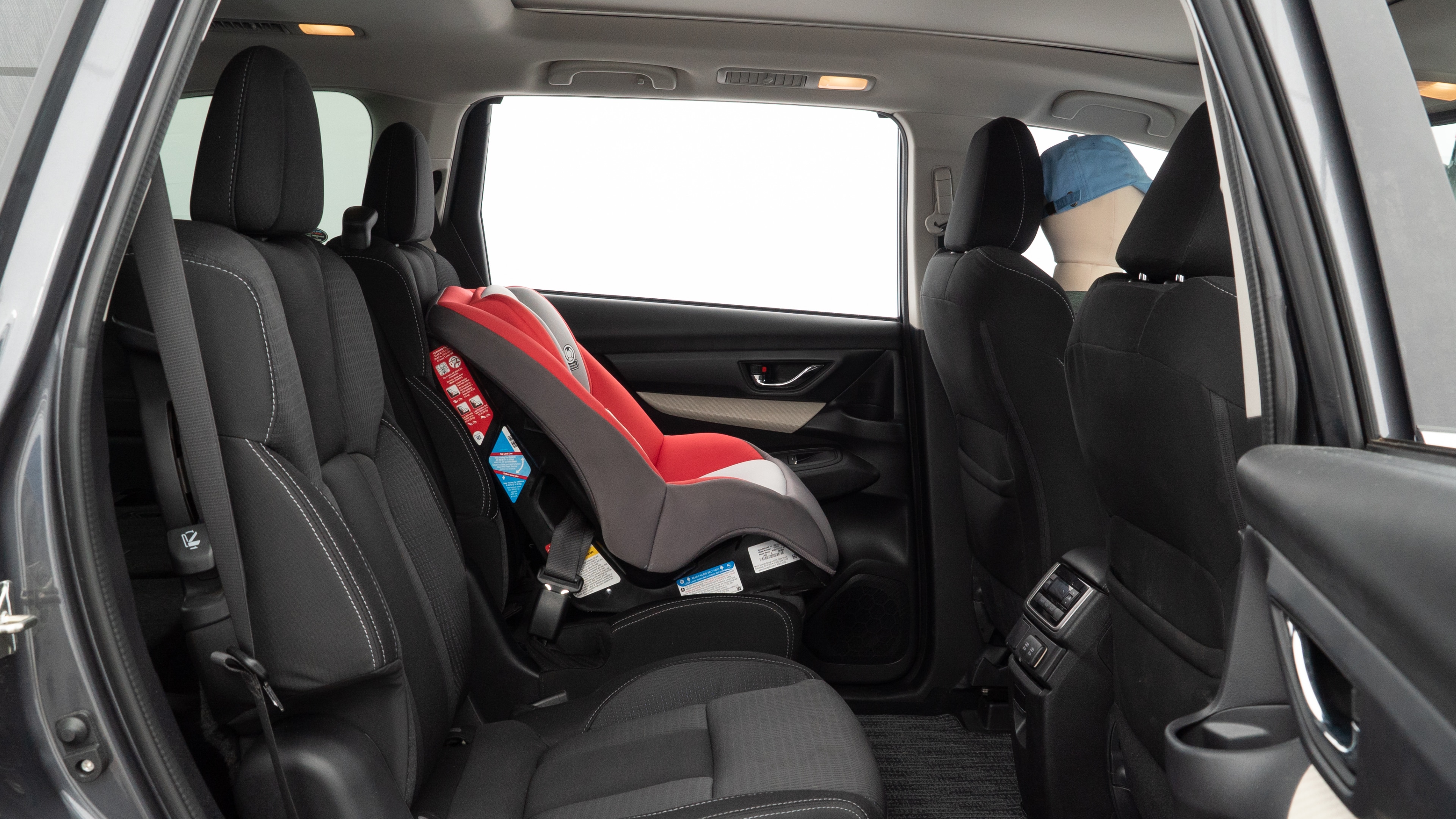 A series of second-row backseat photos is shown including one seating a baby seat and one seating a 6'1" mannequin